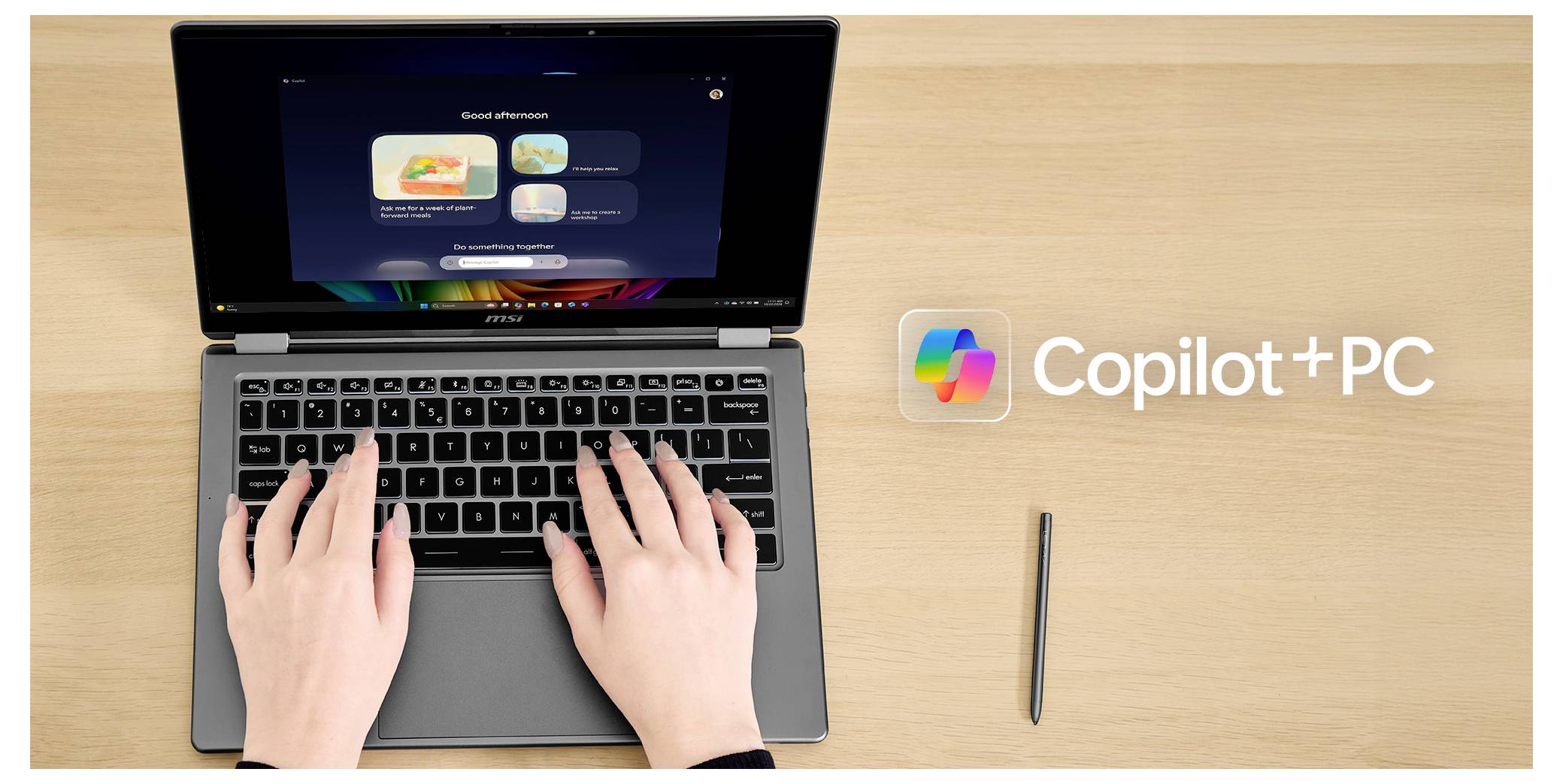Hände, die auf einem Laptop tippen, zeigen den Copilot-App-Bildschirm mit einem "Copilot+PC"-Logo auf einem Holzschreibtisch neben einem Stift.