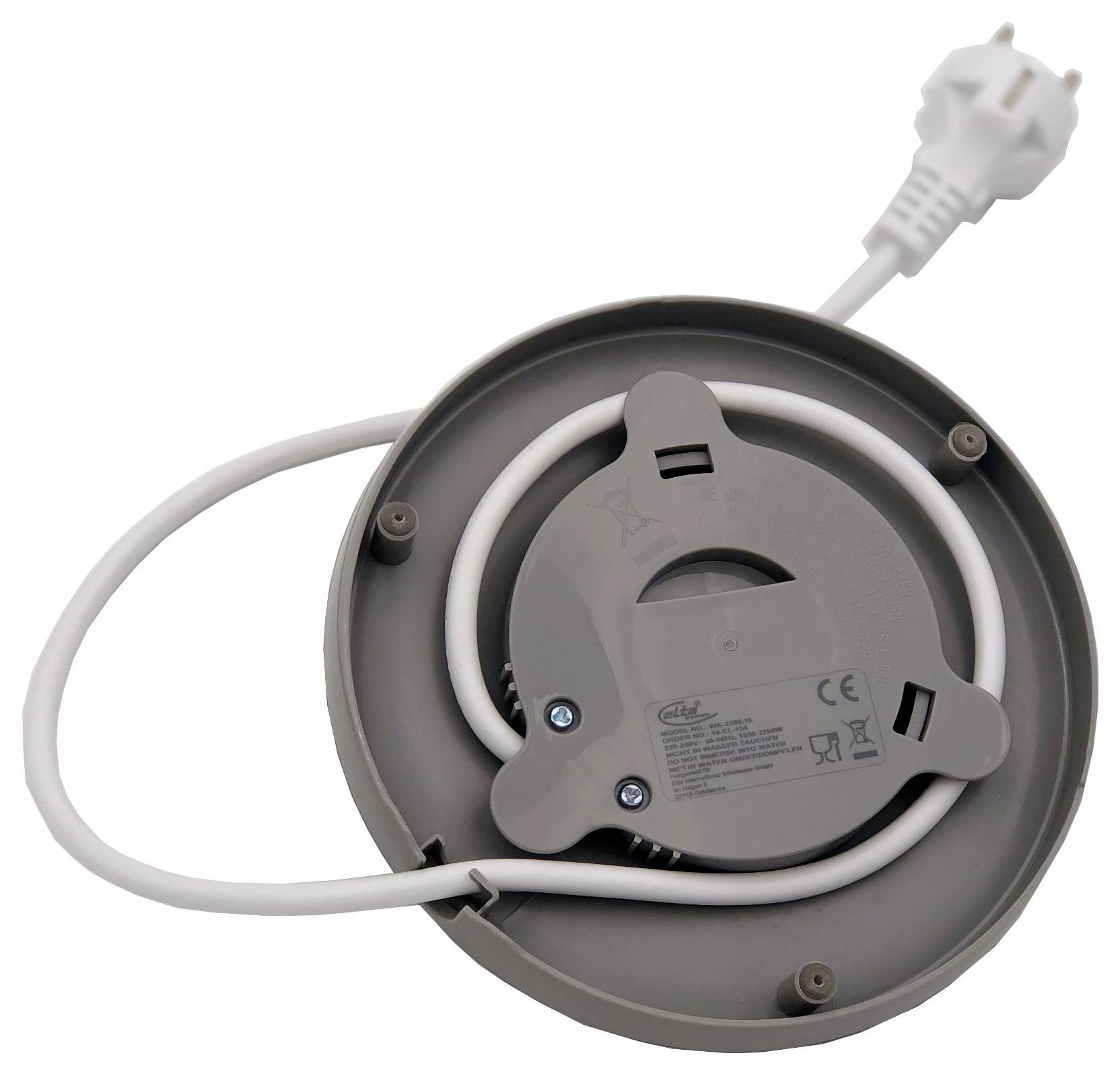 Aufgerolltes weißes Stromkabel und Stecker auf der Rückseite eines runden grauen elektrischen Geräts oder einer Kabelrolle.