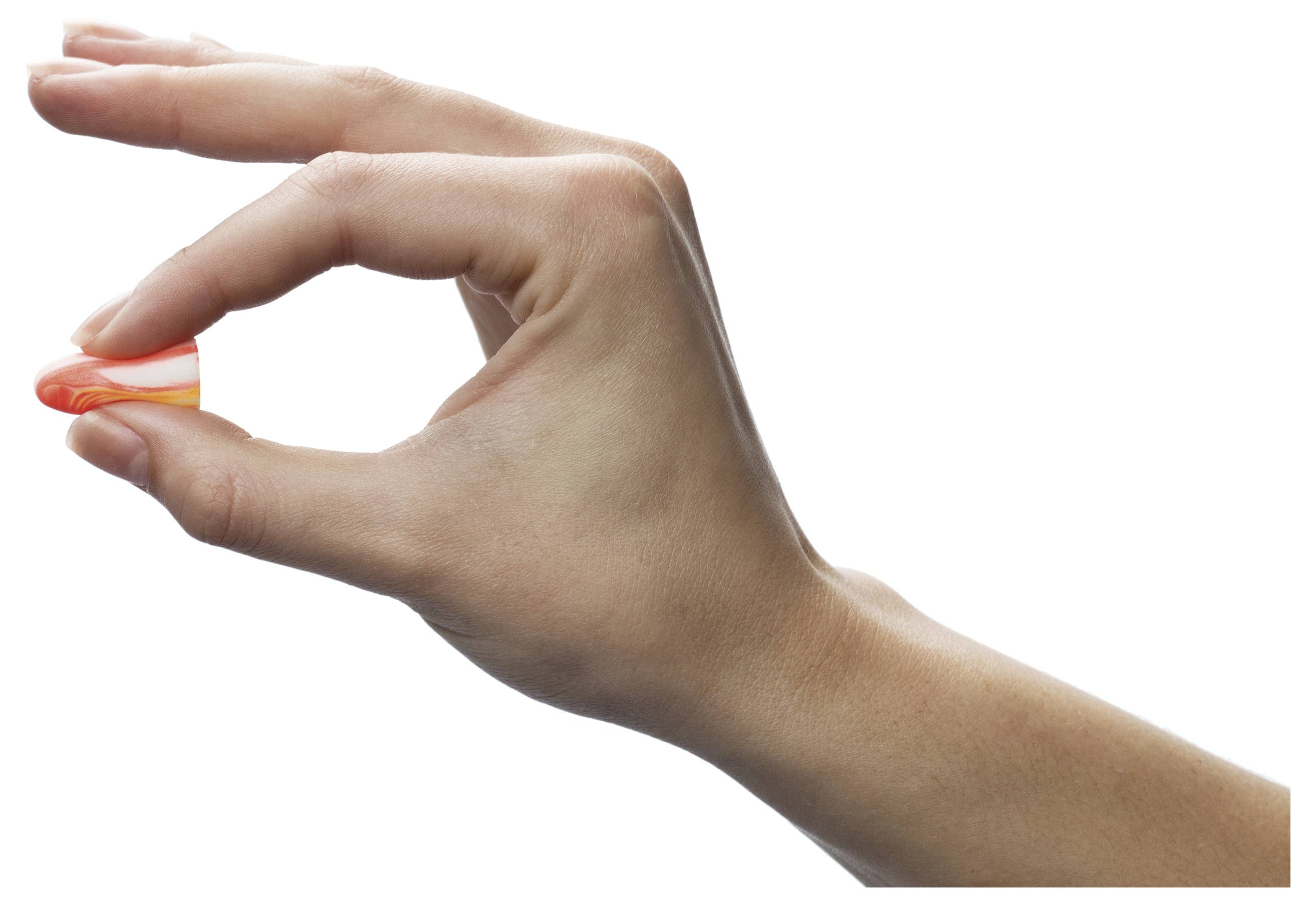 Hand, die eine winzige orange-weiße Kapsel zwischen Daumen und Zeigefinger gegen einen weißen Hintergrund hält.