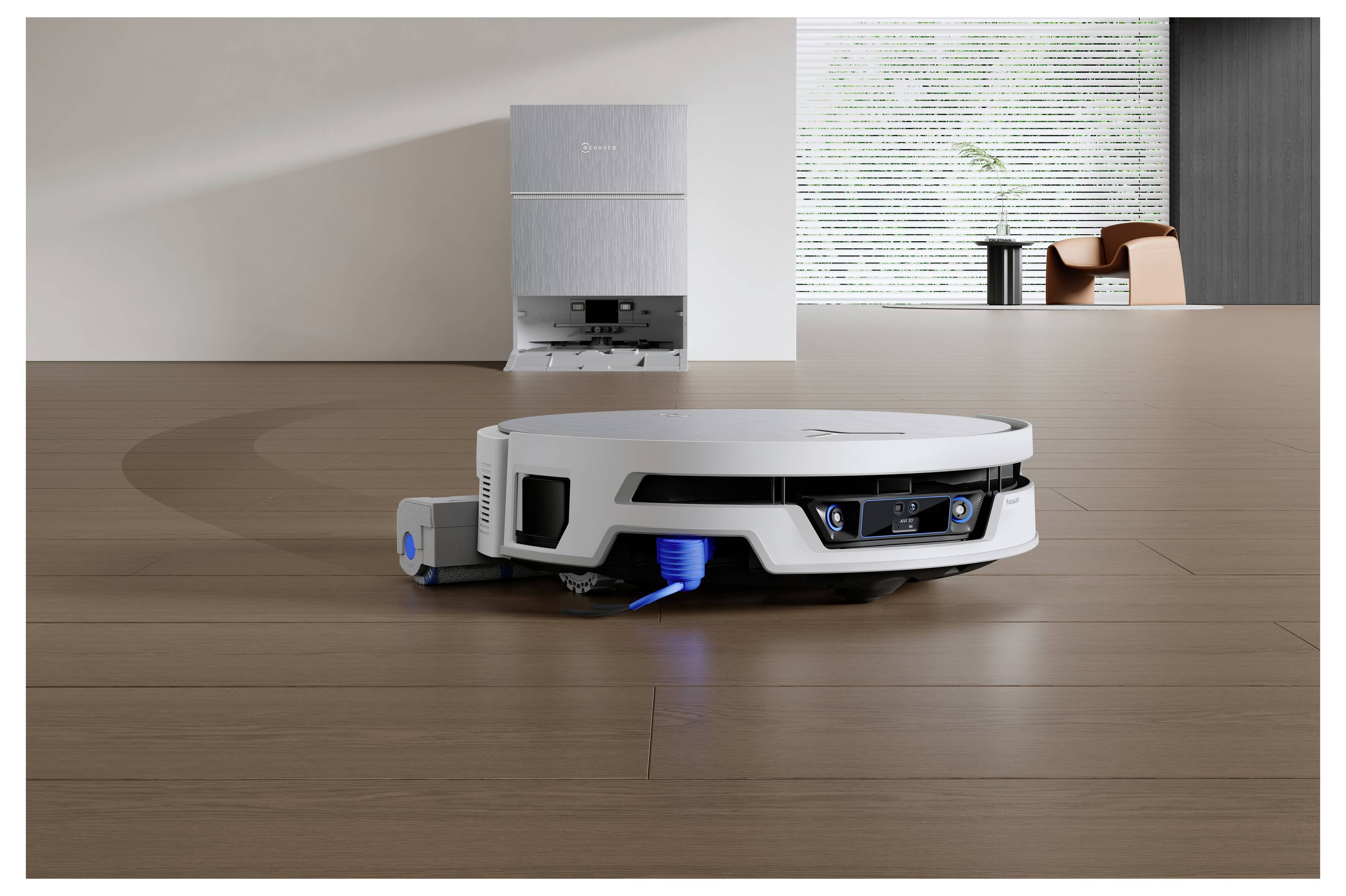 Weißer Roboter-Bodenstaubsauger, der einen Holzboden in einem modernen Zimmer absaugt, mit einer Ladestation im Hintergrund und blauen Anzeigelichtern auf dem Gerät.