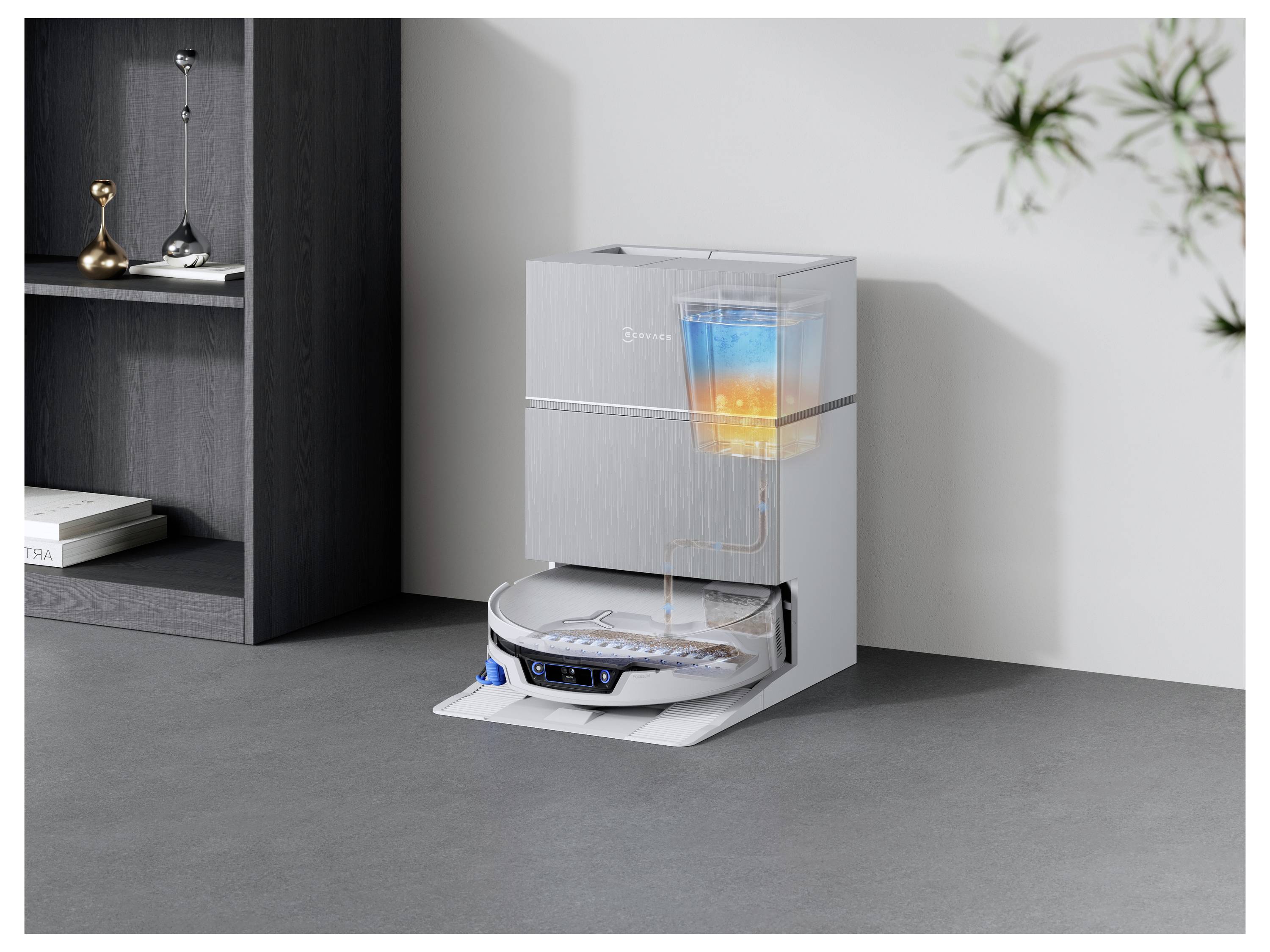 Ein kompaktes Küchengerät mit einer durchsichtigen Kammer zeigt Wasser und farbige Schichten im Inneren, was auf einen Filtrations- oder Reinigungsprozess hindeutet.