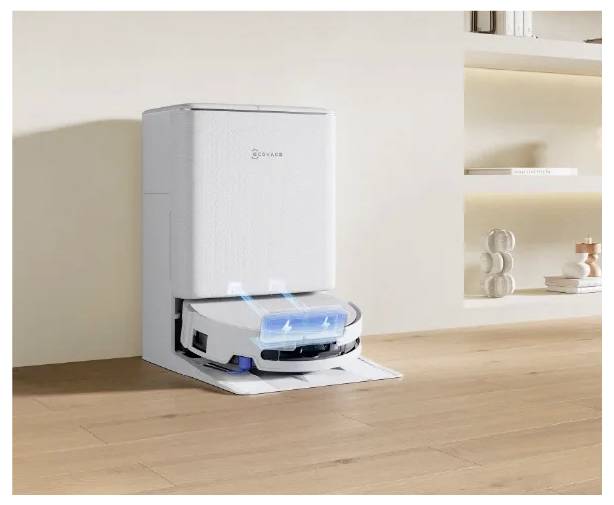 Ein Staubsaugerroboter entleert sich selbst in eine weiße, selbstentlerende Ladestation in einem sauberen, minimalistischen Zimmer.