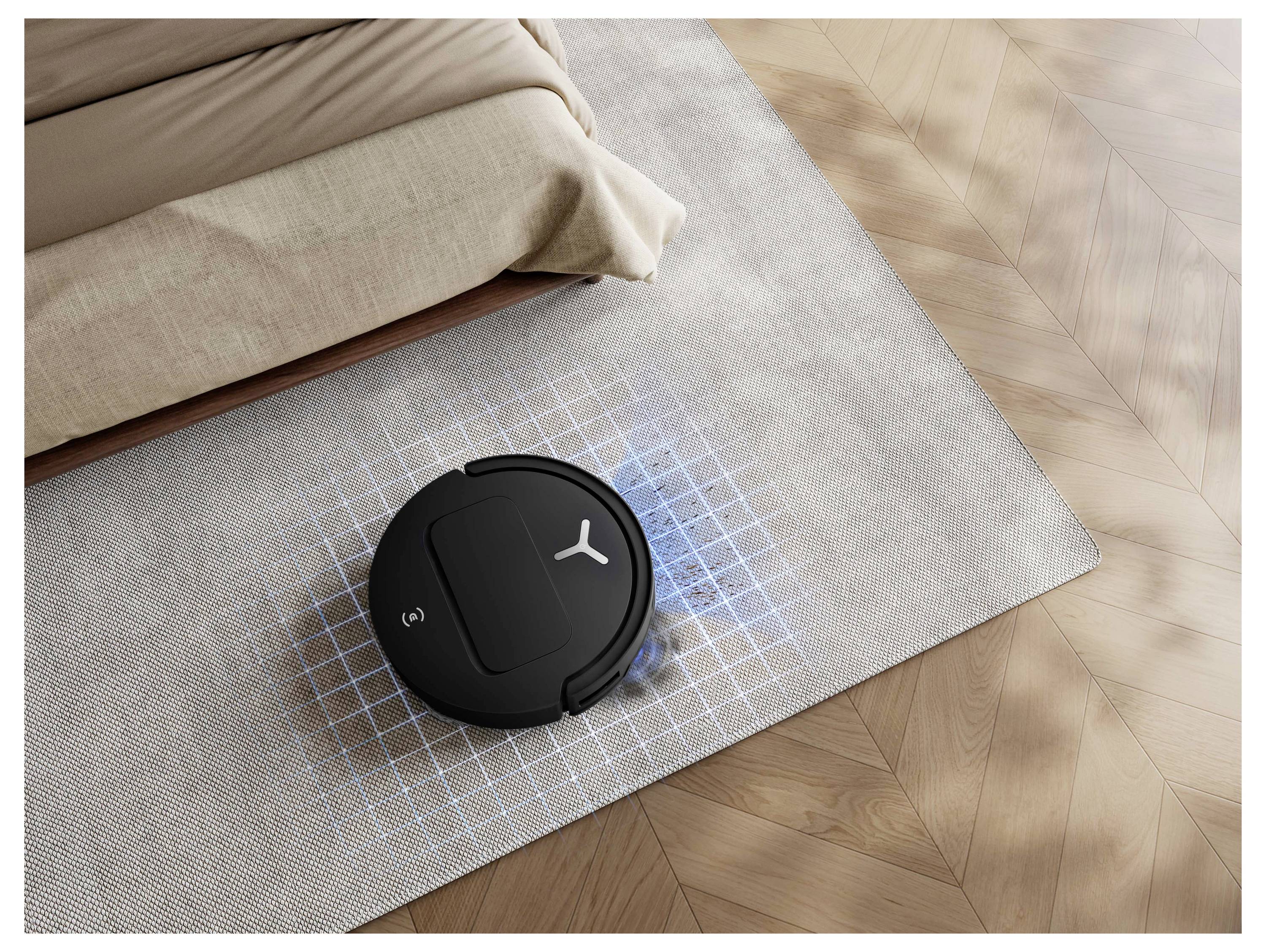 Schwarzer Roboter-Staubsauger reinigt einen Wohnzimmerteppich neben einem Sofa, mit einem blauen Gitter, das seine kartierte Reinigungsfläche zeigt.