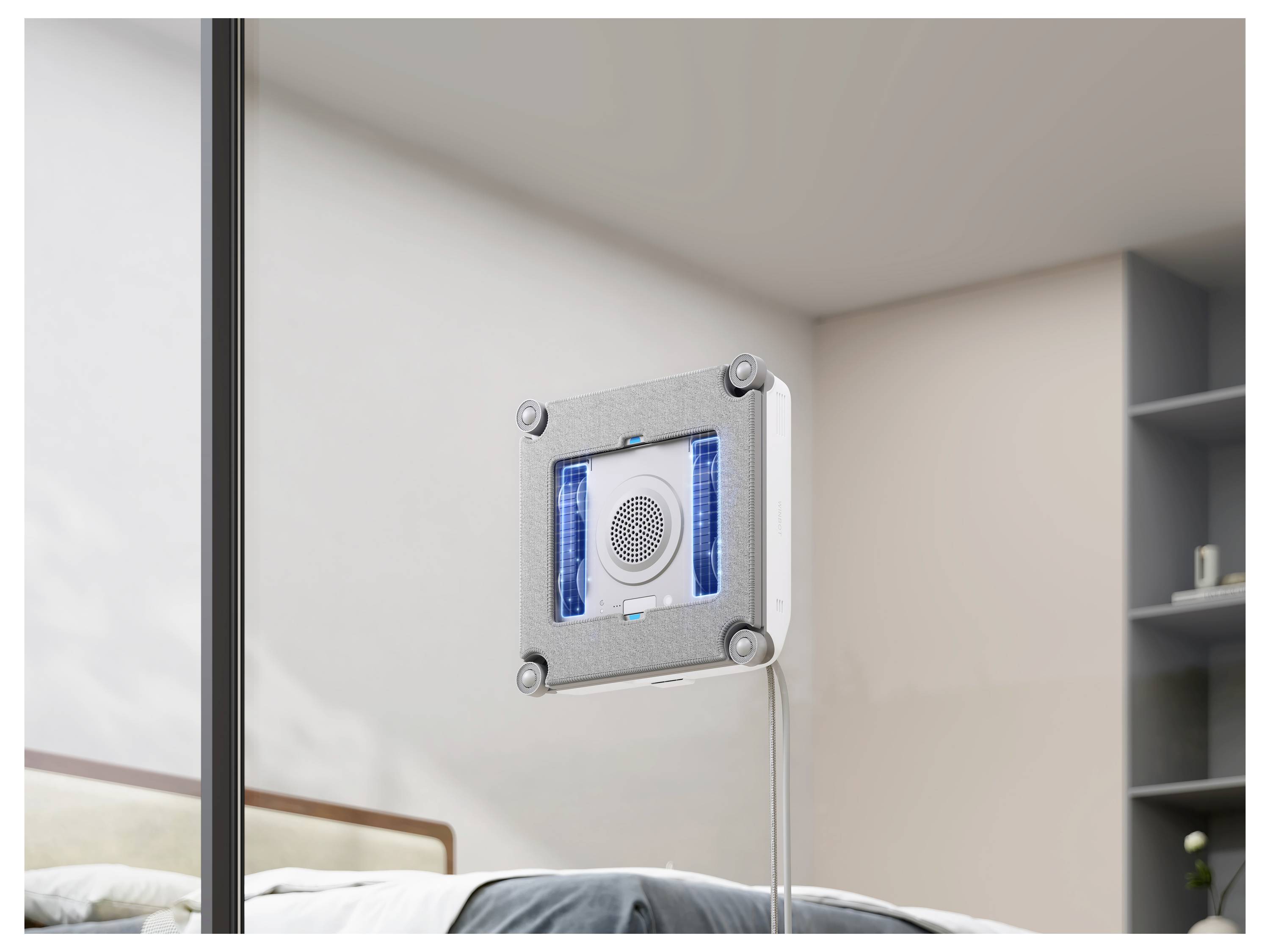 Wandmontierter quadratischer Luftreiniger oder Ventilator mit blau beleuchteten Lüftungsöffnungen neben einem Bett in einem modernen Schlafzimmer.