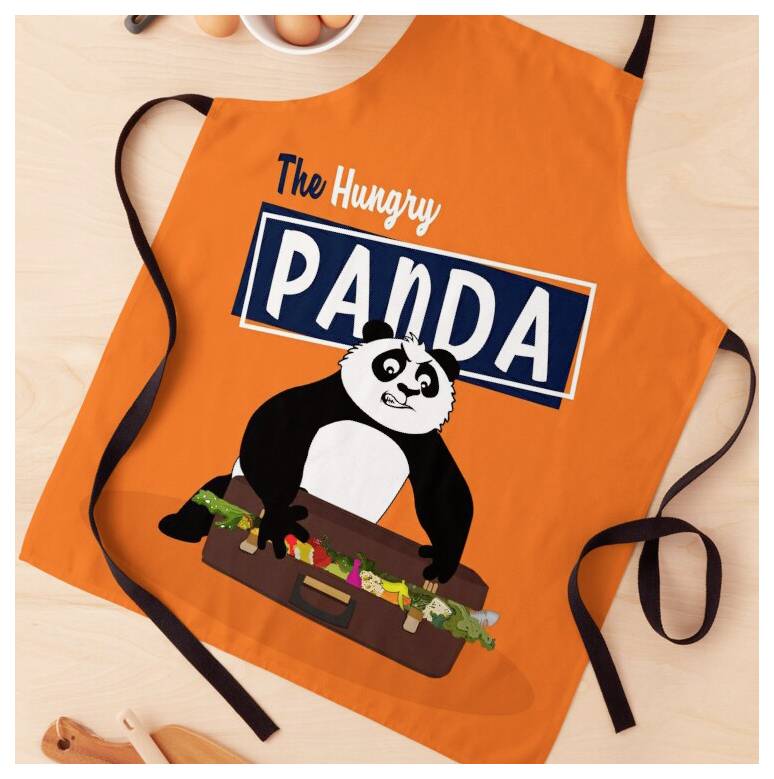 Orange-farbige Schürze mit dem Text „The Hungry PANDA" und einem Cartoon-Panda, der einen Koffer hält, flach ausgelegt mit schwarzen Bindebändern.