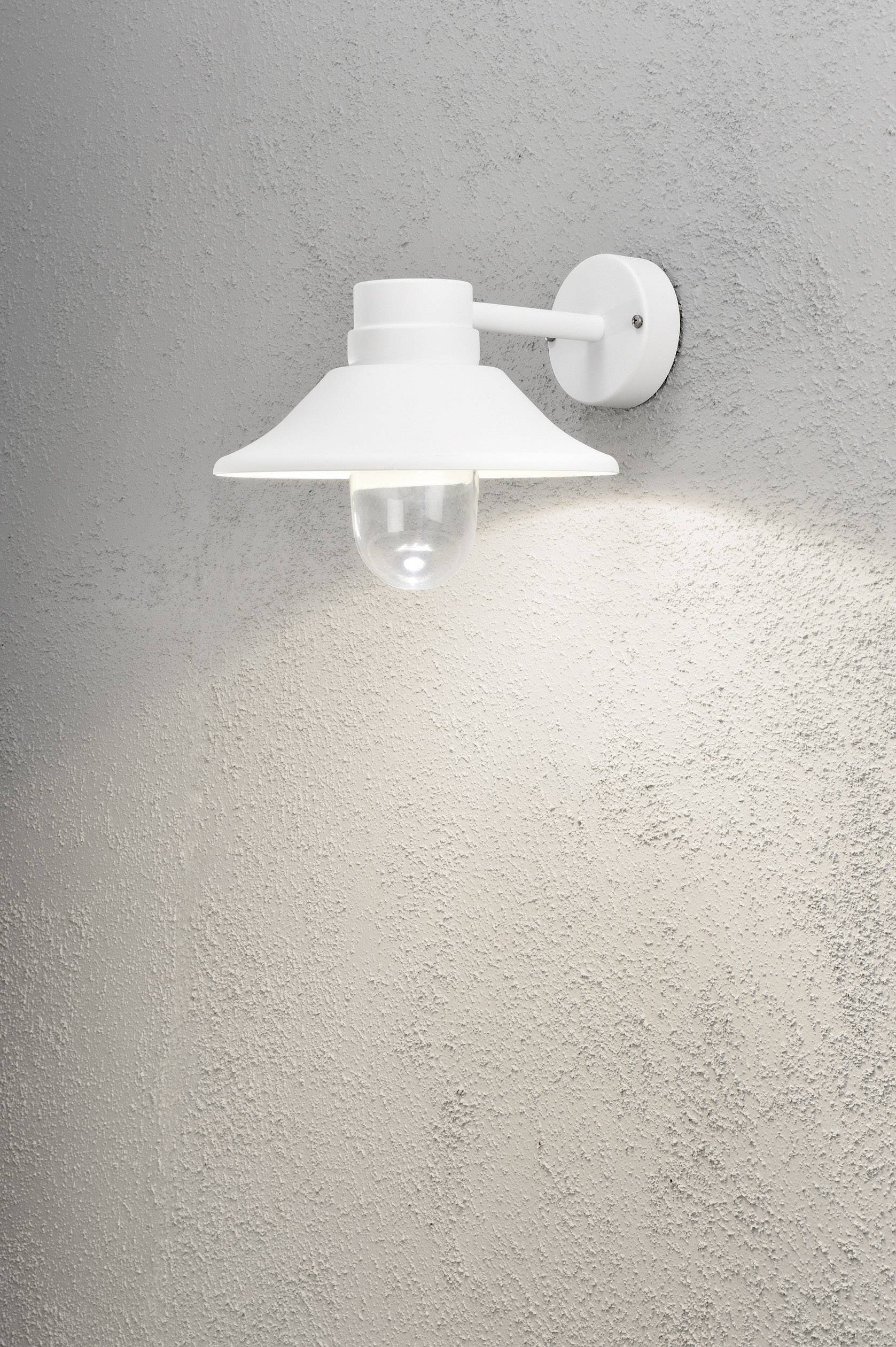 Weiße Wandleuchte mit schlichtem Design leuchtet an grauer Wand. Beleuchtet sanft den Bereich darunter.