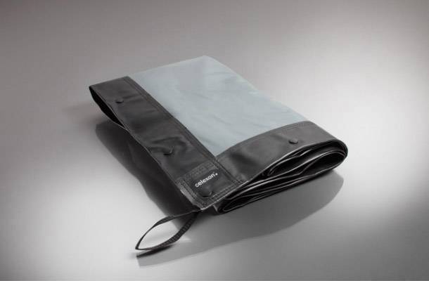 Zusammengefaltete Tasche aus Leder und Stoff in Schwarz und Grau mit Griff.