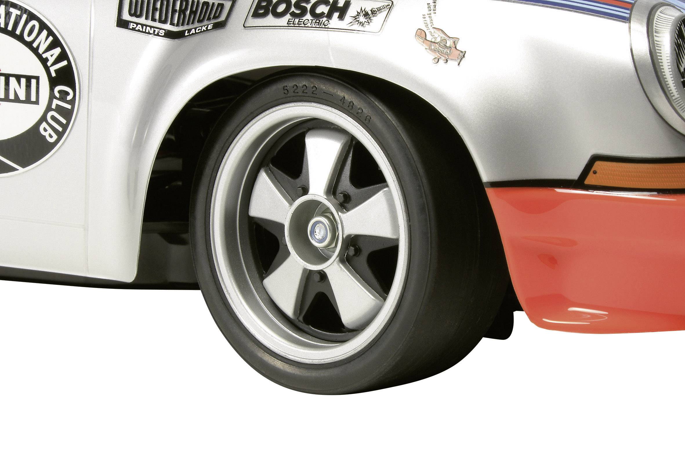 Nahaufnahme eines Autoreifens mit klassischem Felgendesign. Links oben ist ein Logo mit der Aufschrift 'International Club' sichtbar.