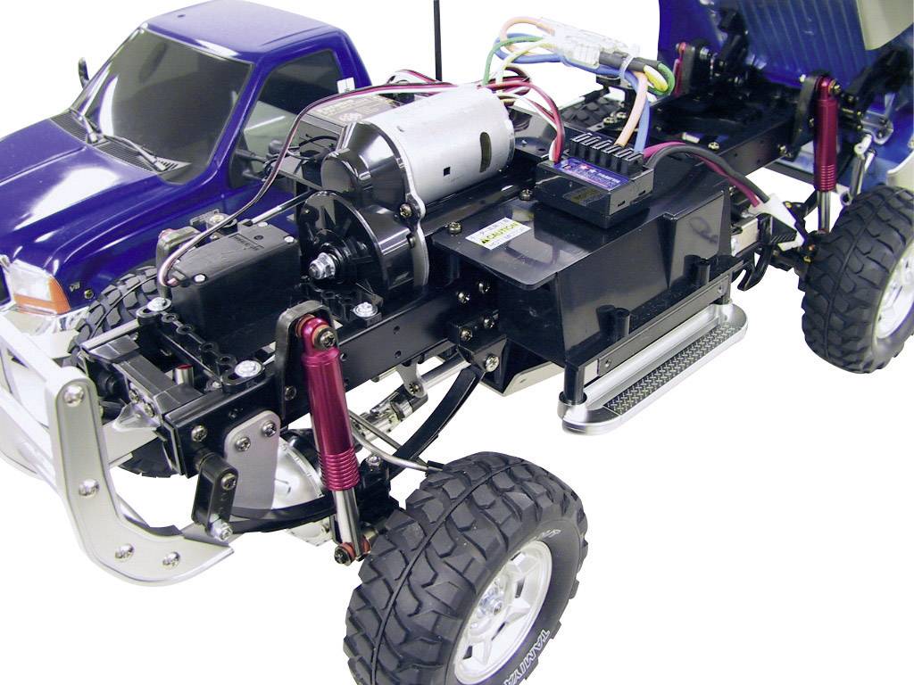 Ferngesteuertes Modellauto mit geöffneter Karosserie, zeigt Motorkomponenten und Federung.