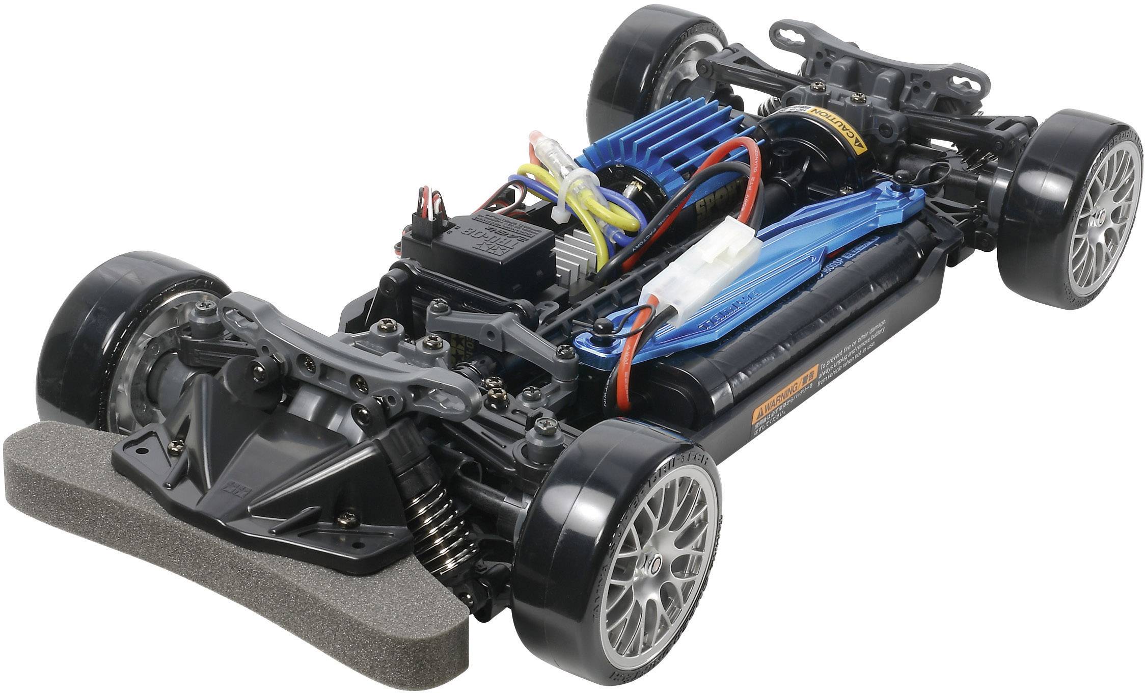 Modellauto-Chassis mit sichtbarer Elektronik und verkabelten Komponenten, montierte Reifen, Vorderradaufhängung und Motor.