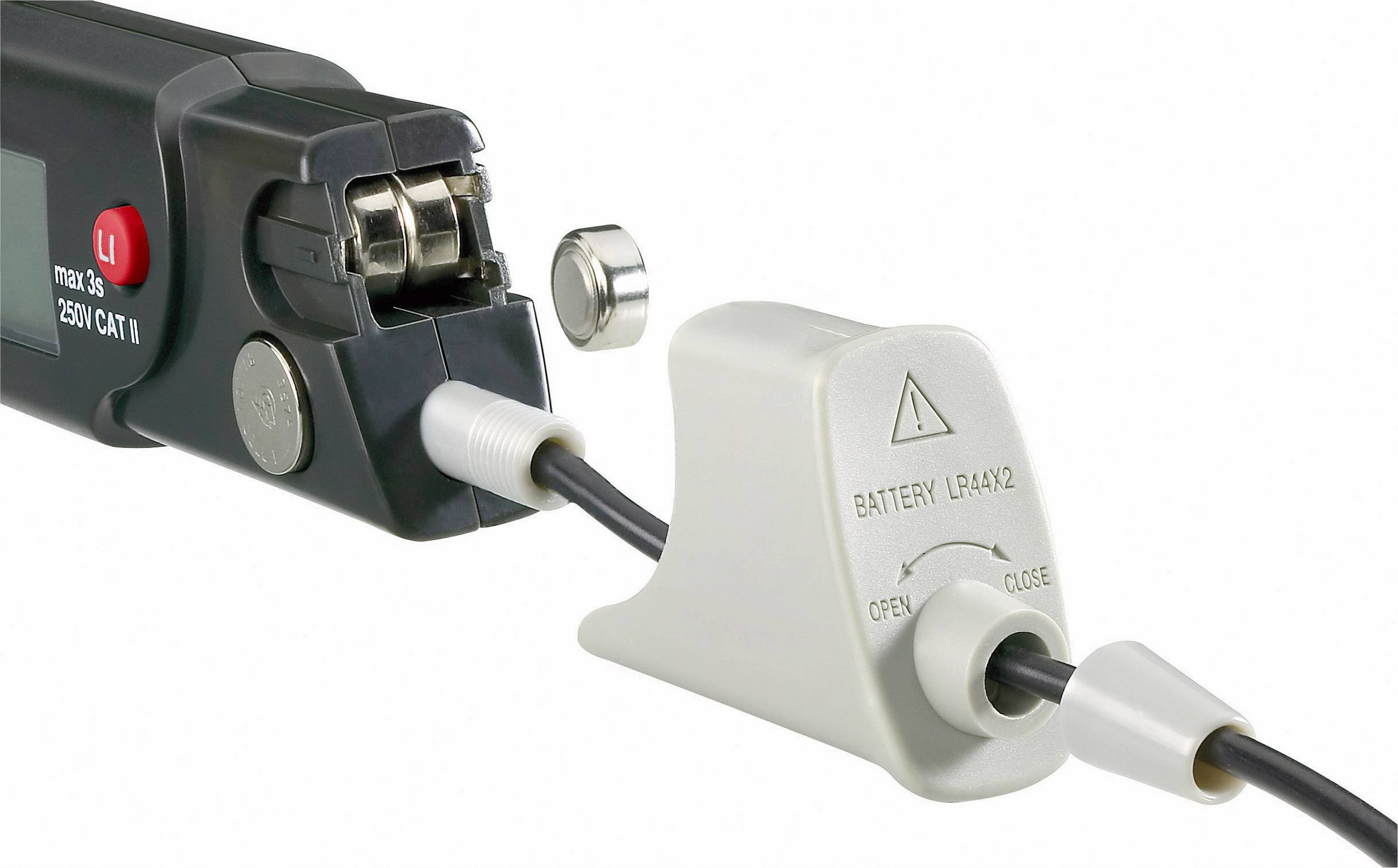 Nahaufnahme eines Geräts mit angeschlossenem Kabel und abnehmbarem Batteriedeckel. Warnhinweise auf dem Batteriefach.