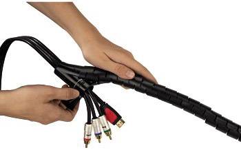 Eine Person organisiert mehrere Kabel mit einem schwarzen Kabelschlauch, um sie ordentlicher zu bündeln und zu schützen.