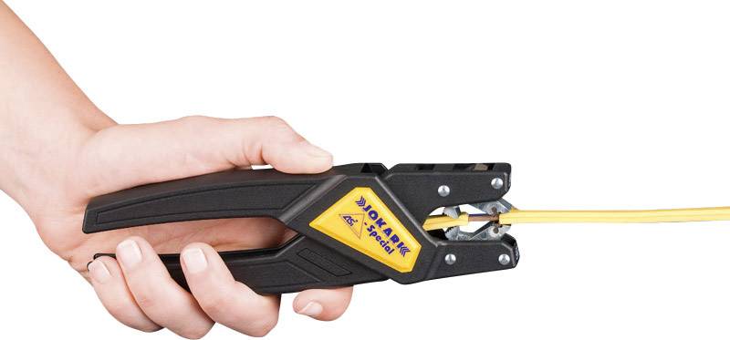 Hand hält einen Kabelabisolierer, der ein gelbes Kabel abisoliert. Das Werkzeug ist schwarz mit einem gelben Logo.