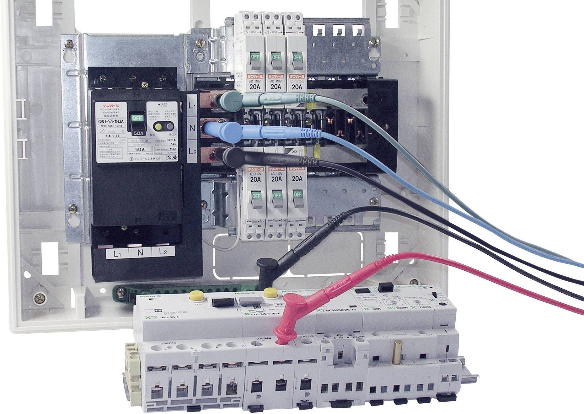 Ein Schaltschrank mit mehreren elektrischen Komponenten und farbigen Kabeln, die an verschiedenen Schaltkreisen angeschlossen sind.