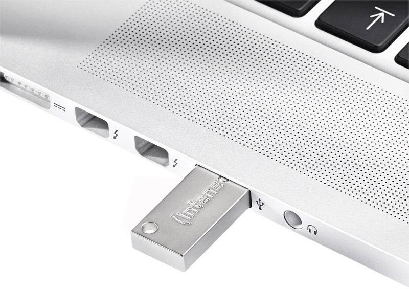 Ein USB-Stick steckt in einen Laptop. Der Stick befindet sich neben einem Kopfhöreranschluss und zwei Thunderbolt-Anschlüssen.