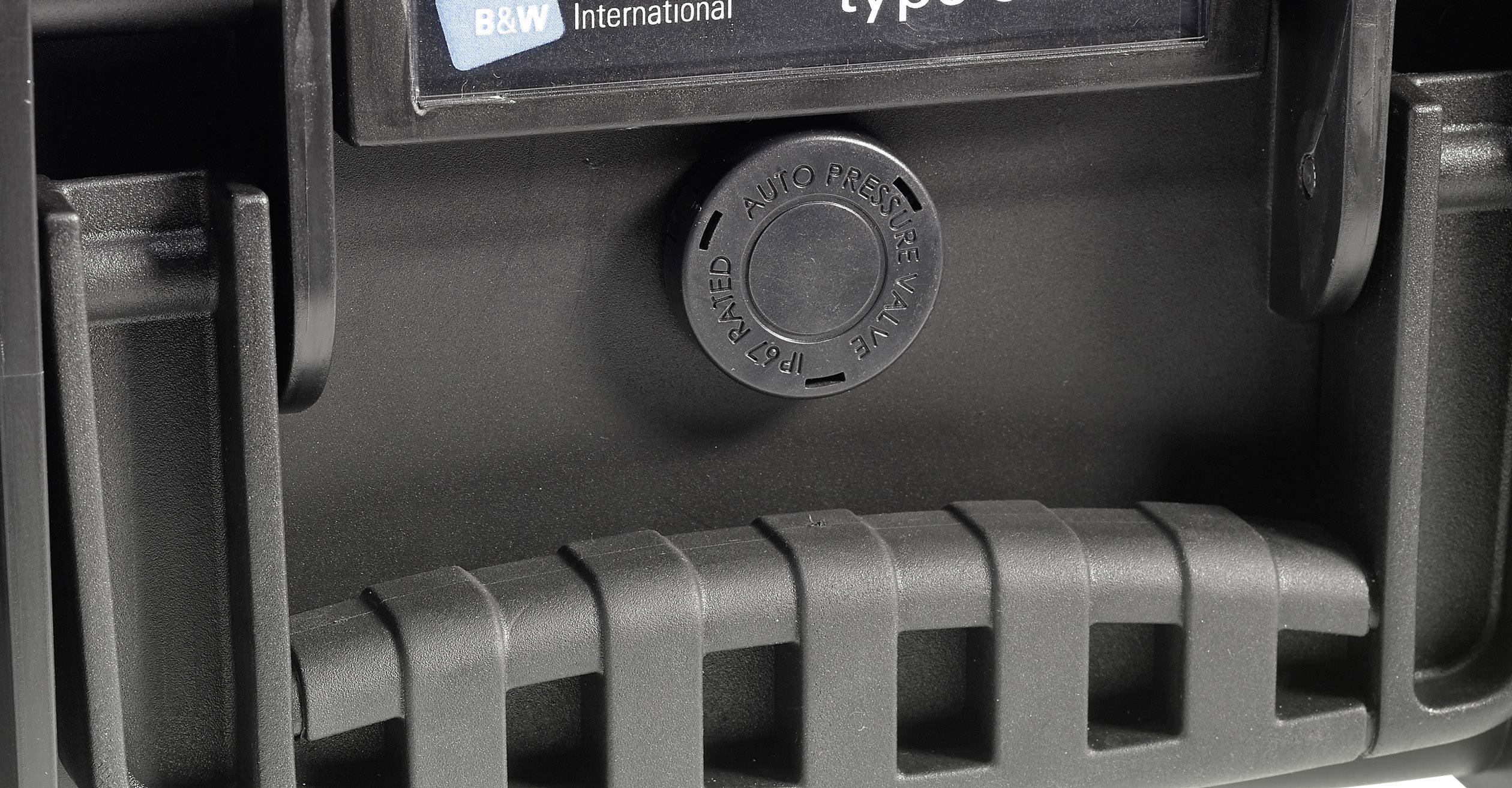 Detailaufnahme eines schwarzen Kunststoffgriffs mit markierter Automatikentlüftung und Logo von B&W International im Hintergrund.