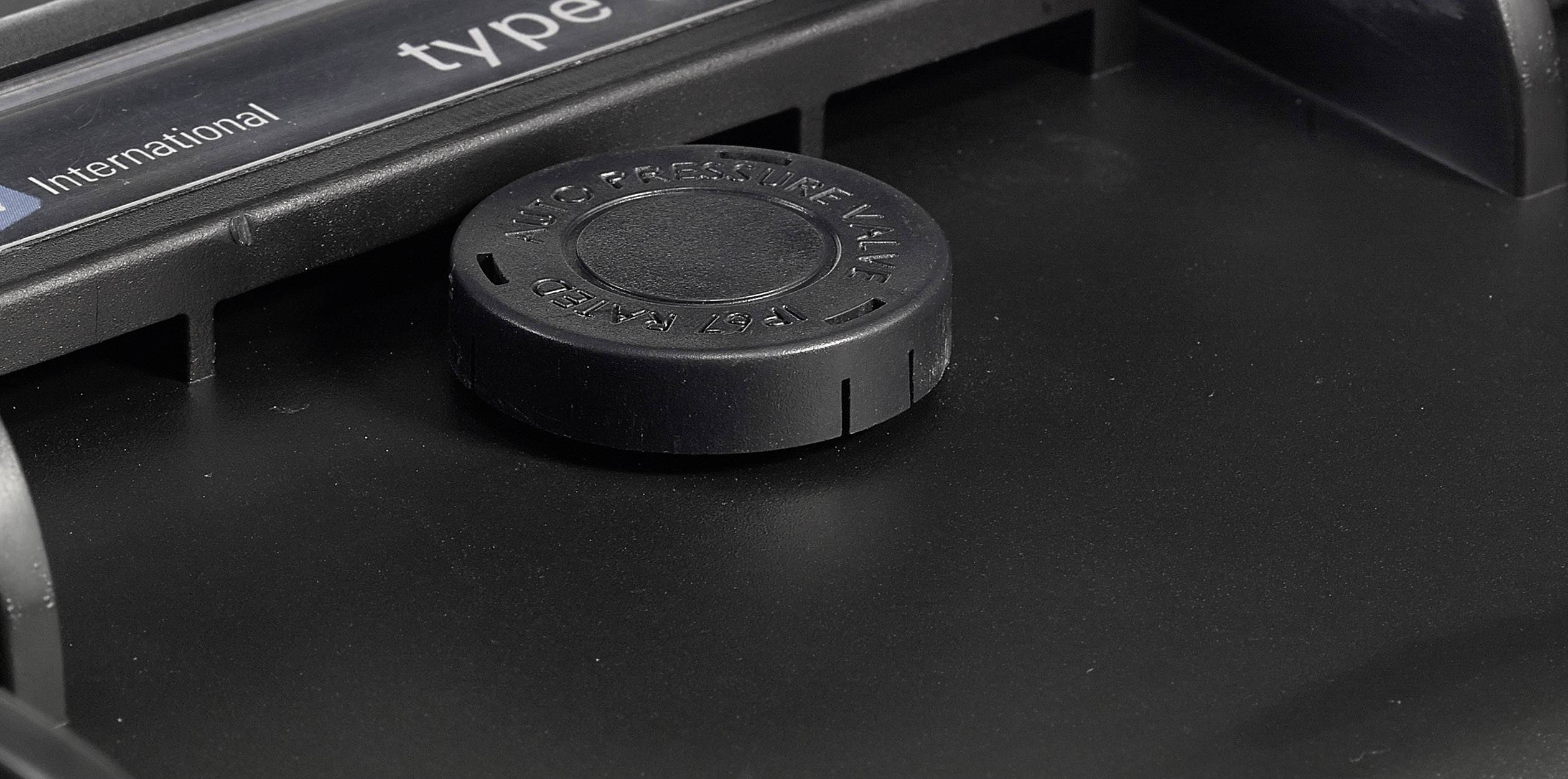 Ein schwarzer Drehknopf auf einem Gerät, umgeben von einem Gehäuse. Links oben sind teilweise sichtbare Beschriftungen.