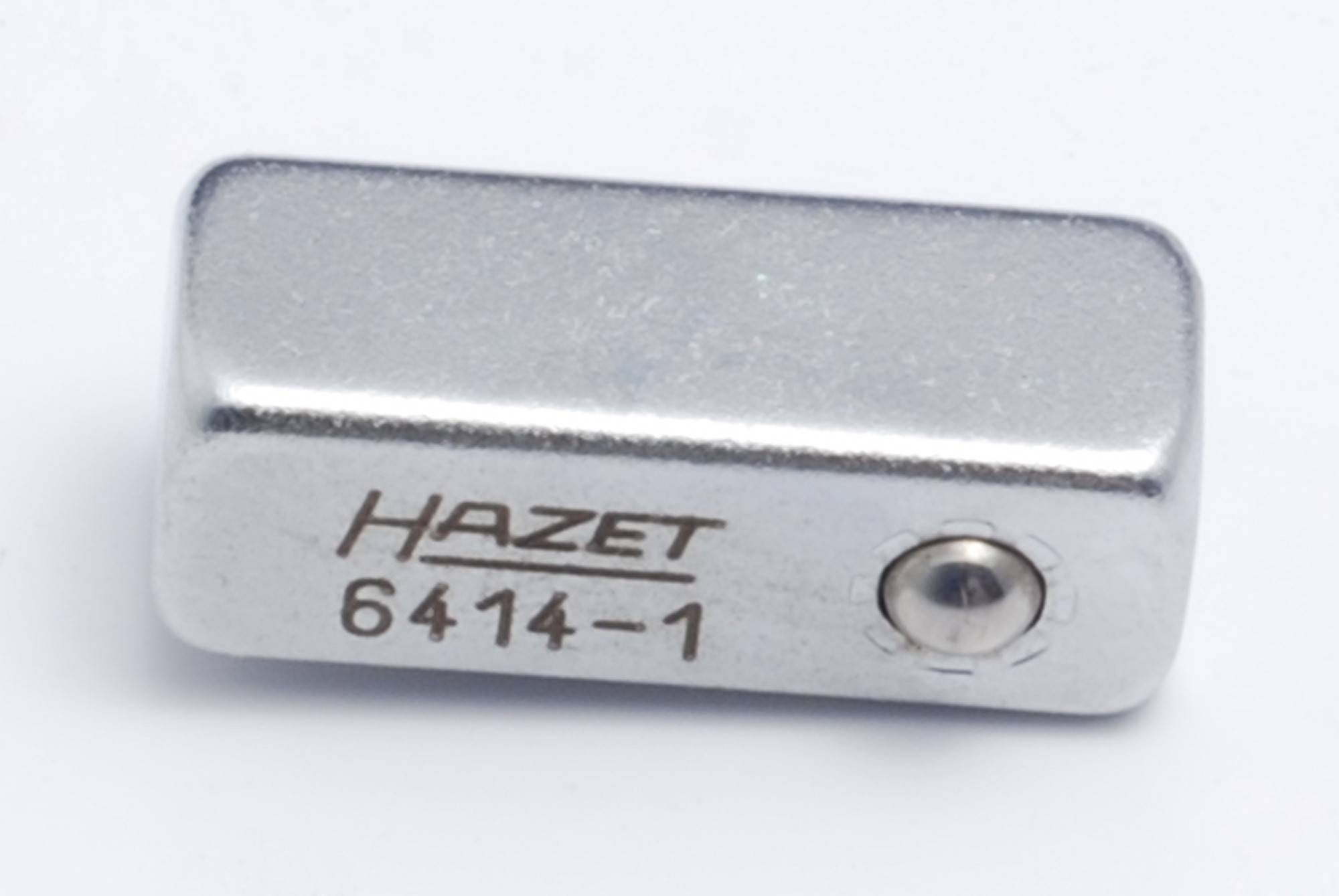 Metallischer Adapterwürfel mit der Gravur 'HAZET 6414-1'.