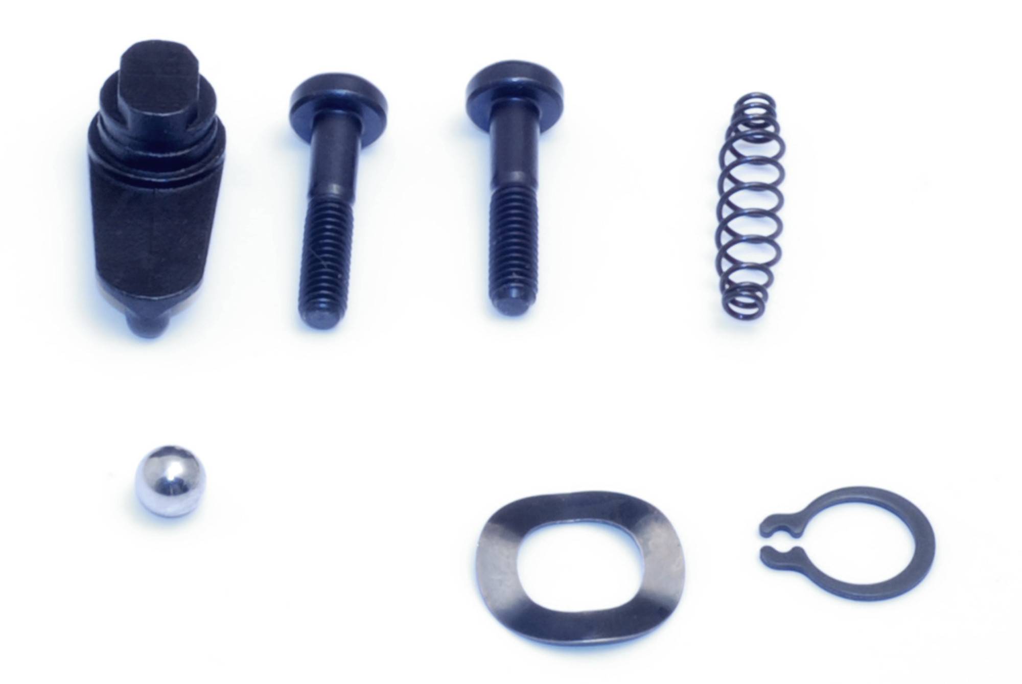 Ein Set aus acht schwarzen Metallteilen auf weißem Hintergrund, darunter Schrauben, eine Feder und verschiedene Befestigungselemente.