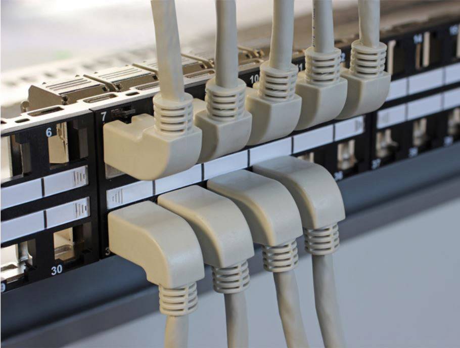 Ein Netzwerk-Patchpanel mit mehreren eingesteckten Ethernet-Kabeln zeigt eine organisierte Kabelverwaltung in einem Rechenzentrum.