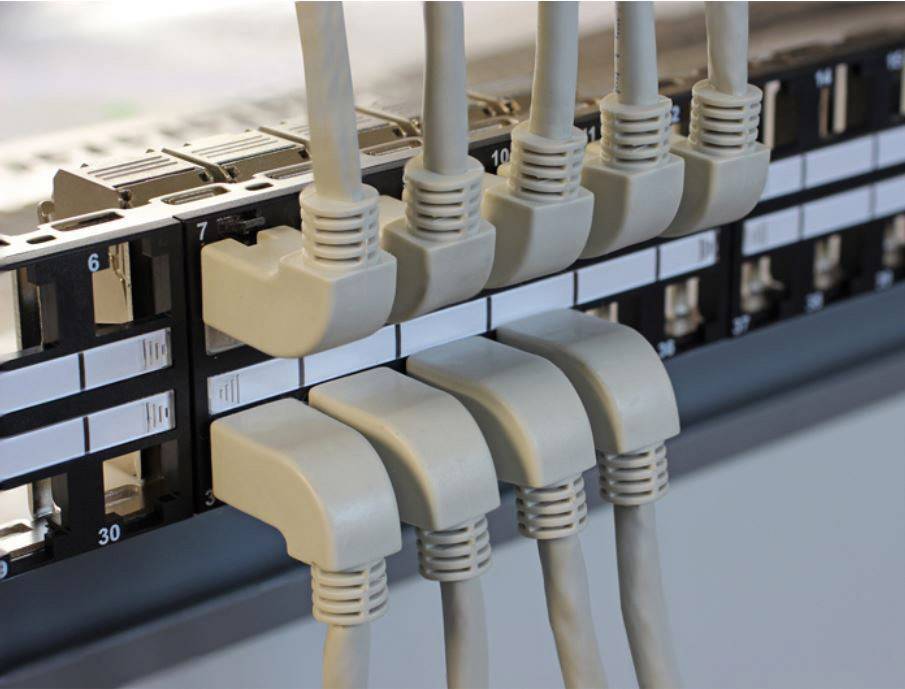 Ein Netzwerk-Patchpanel mit neun eingesteckten Ethernet-Kabeln. Es zeigt die Organisation und Verbindung von Netzwerkkabeln.