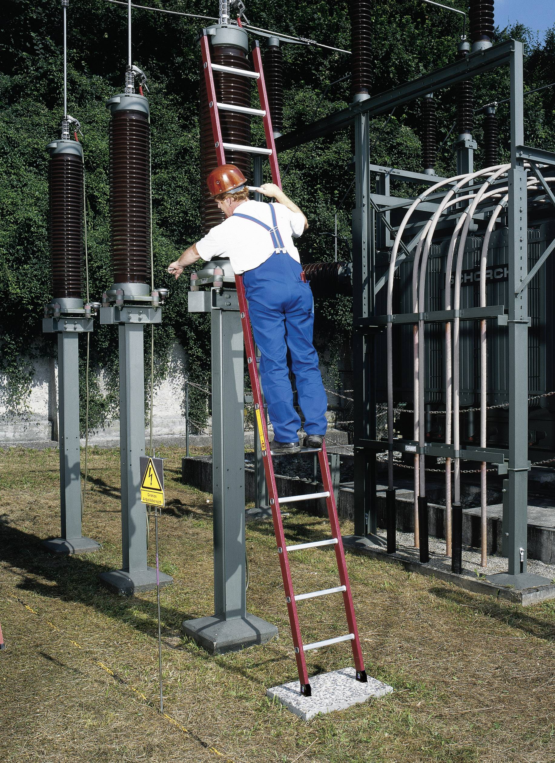 Eine Person in Schutzkleidung steht auf einer roten Leiter und arbeitet an einer elektrischen Anlage im Freien.