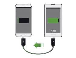Ein Smartphone lädt ein anderes über ein USB-OTG-Kabel. Beide Telefone zeigen Akkusymbole, eines lädt Strom, das andere gibt Strom ab.