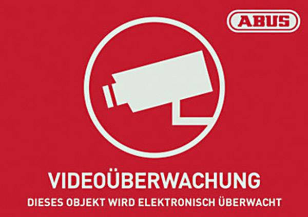 Rotes Schild mit stilisierter Kamera und Text 'VIDEOÜBERWACHUNG - Dieses Objekt wird elektronisch überwacht'. Markenlogo oben rechts.