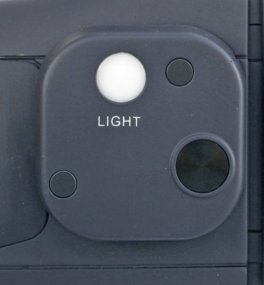 Nahaufnahme eines Polaroid-Kameralichts, quadratisches Modul mit 'LIGHT'-Beschriftung unter einem weißen Sensorfeld, umgeben von drei schwarzen Sensoren.