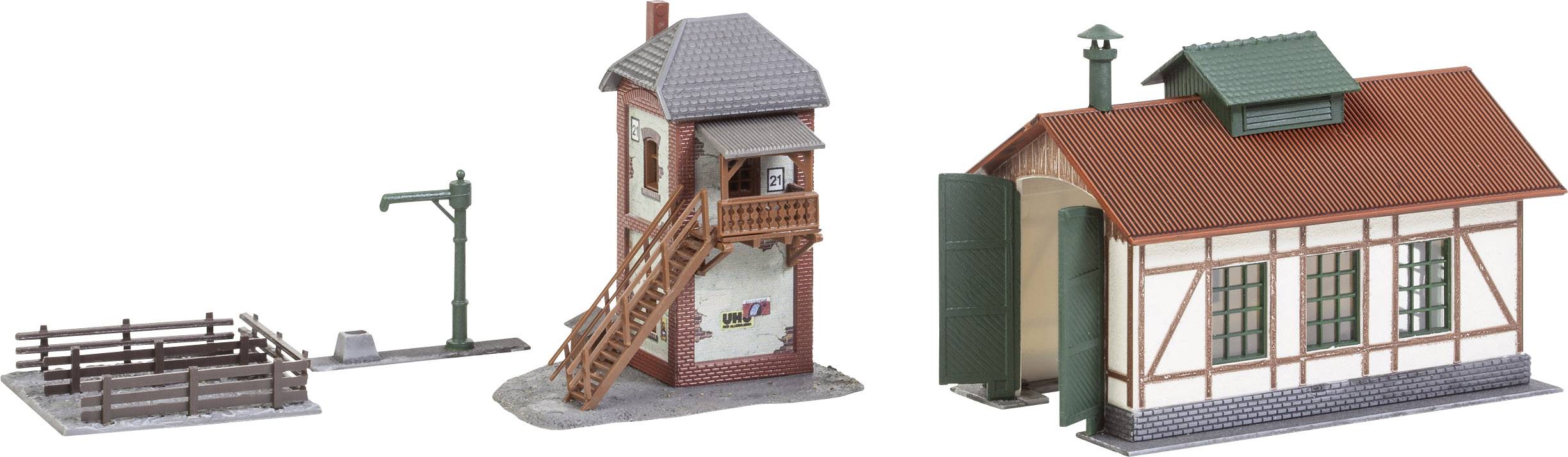 Miniaturmodell eines Bahnhofs mit Viehstall, Wassertank und Fachwerkgebäude. Optimal für eine Eisenbahnlandschaft geeignet.