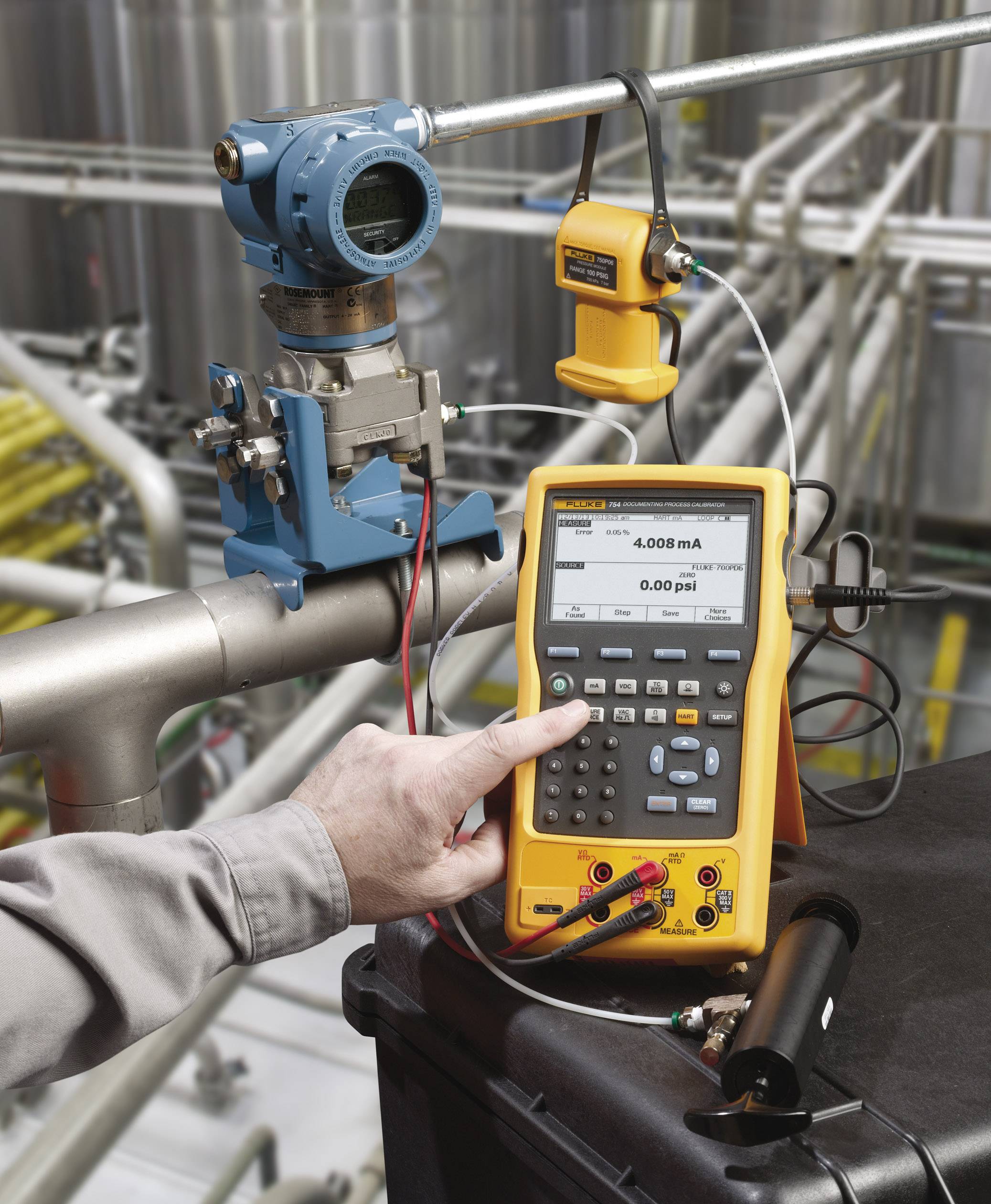 Eine Person kalibriert ein Druckmessgerät mit einem Multimeter in einer industriellen Umgebung, um Präzision sicherzustellen.