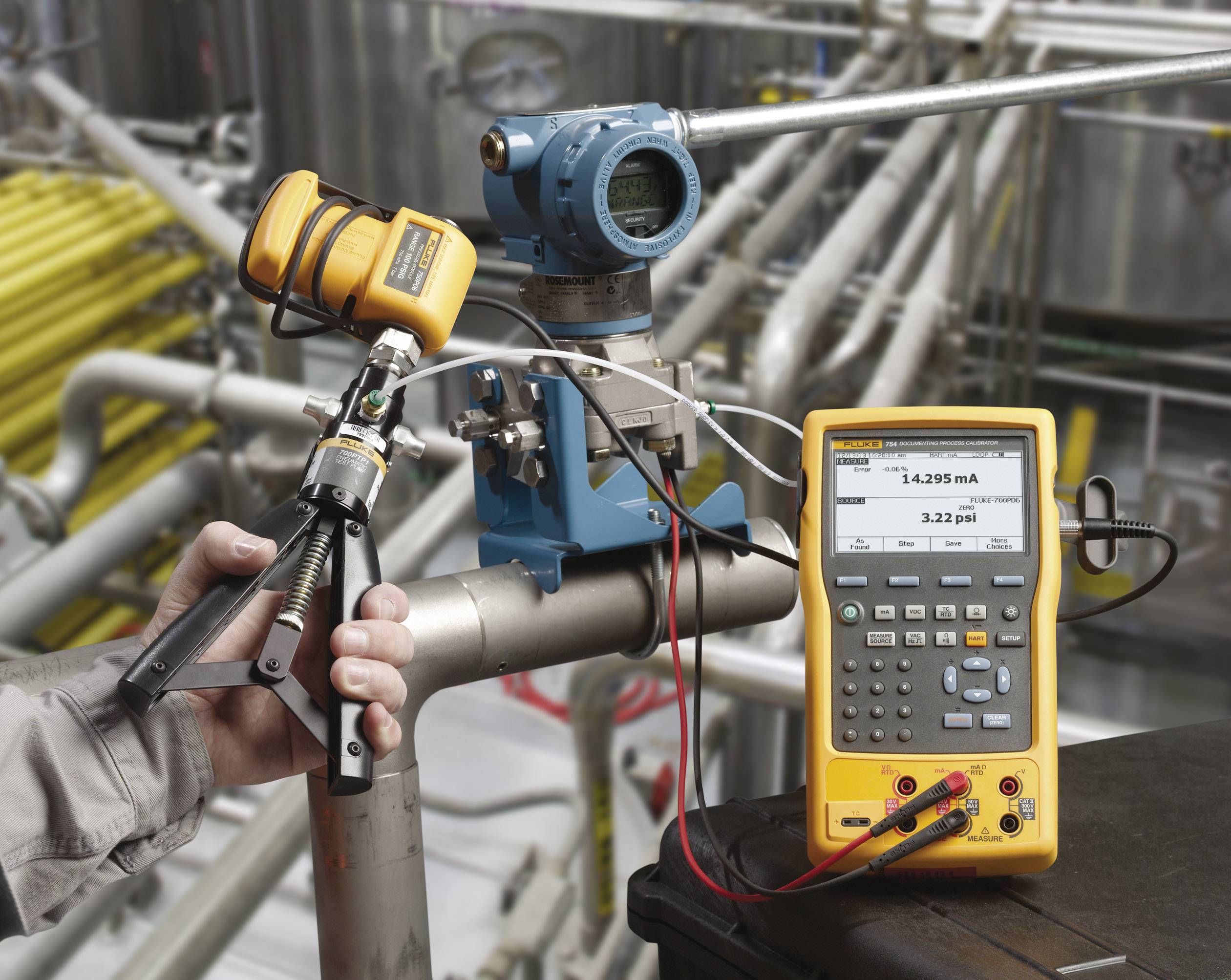 Eine Person kalibriert einen Drucksensor in einer industriellen Umgebung, indem sie ein tragbares Kalibriergerät verwendet.