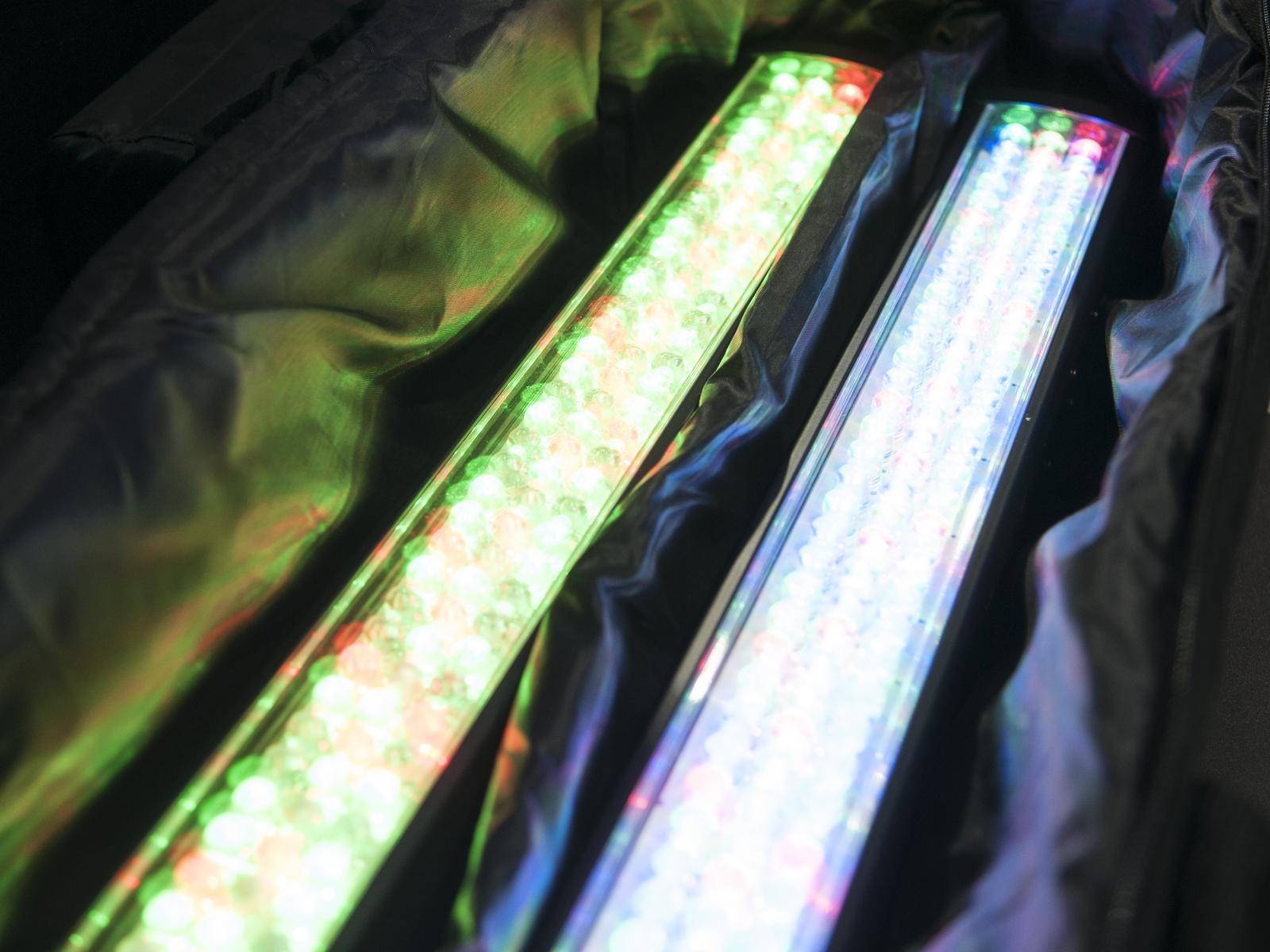 Zwei LED-Lichtleisten leuchten in verschiedenen Farben in einem stoffummantelten Kasten.