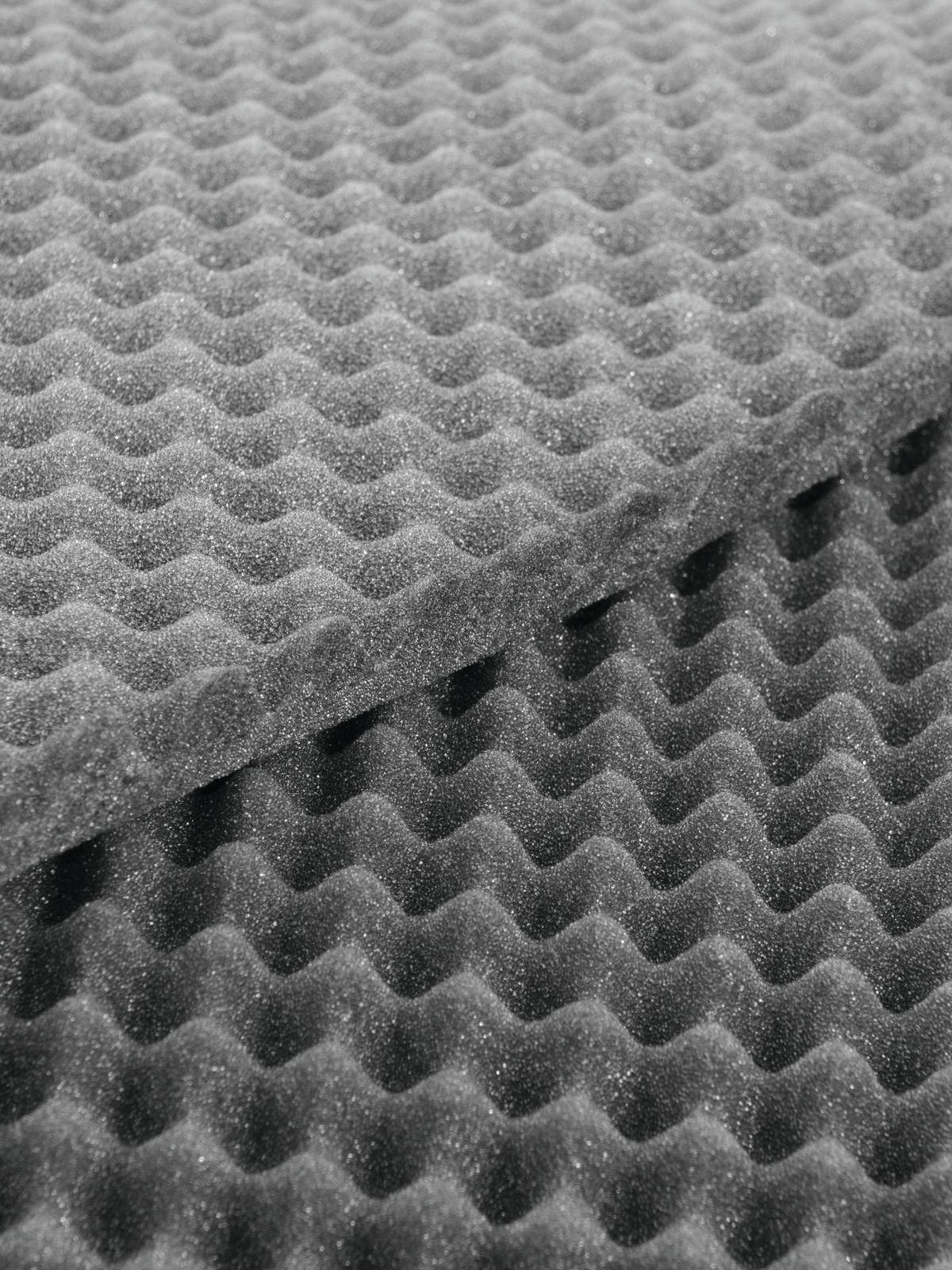 Graue Akustikschaumstoffplatten mit wellenförmigem Muster zur Schallabsorption.