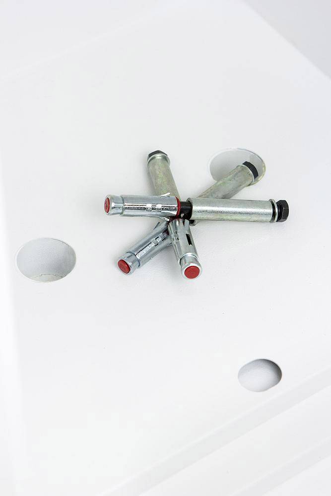 Sechs Metallrohre, die sternförmig auf einer weißen Oberfläche angeordnet sind.