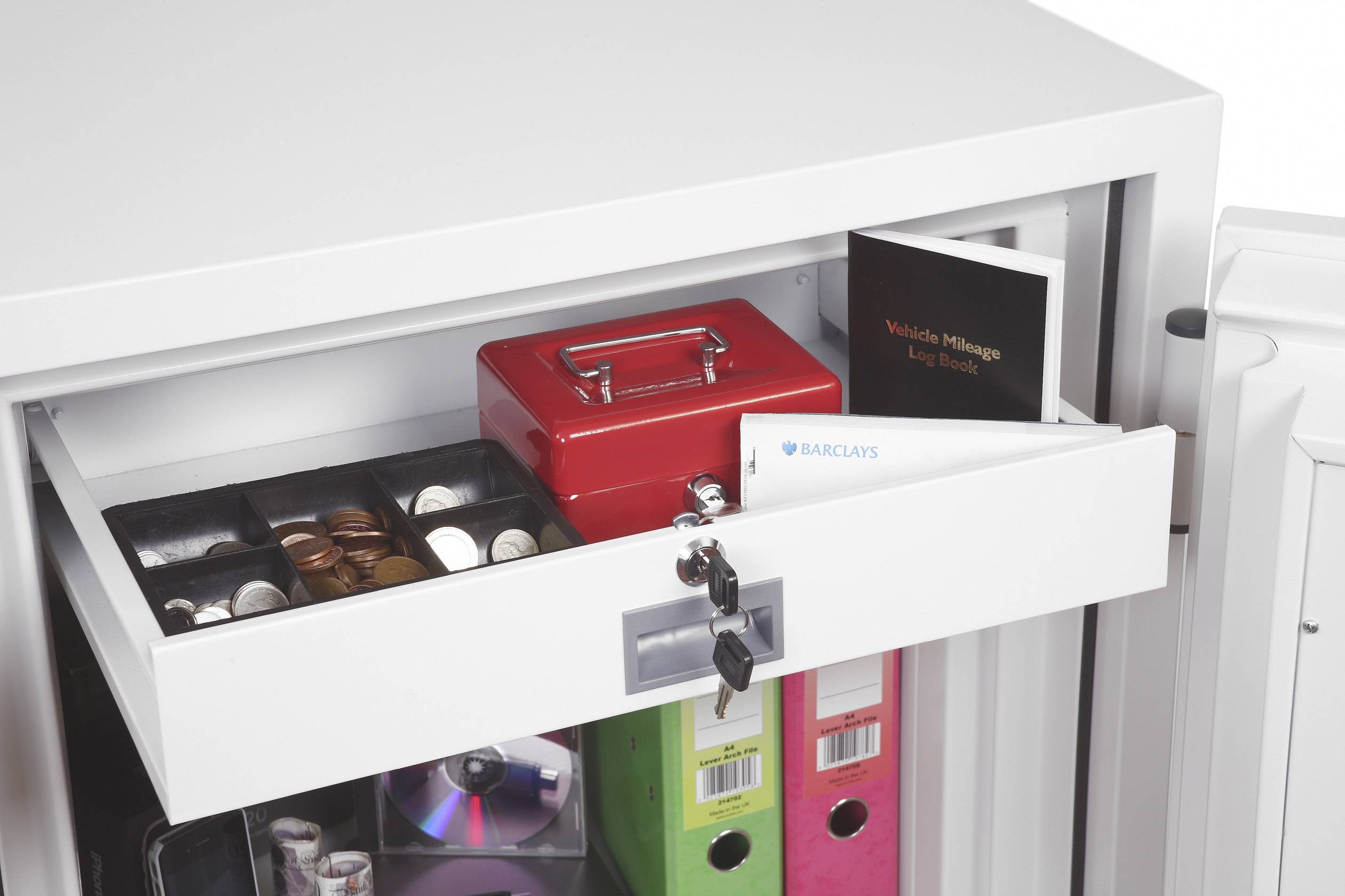 Weiße Schublade in einem Schrank, halb geöffnet, mit Münzen, Schlüsseln, einer roten Box und Dokumenten; sichere Aufbewahrung dargestellt.