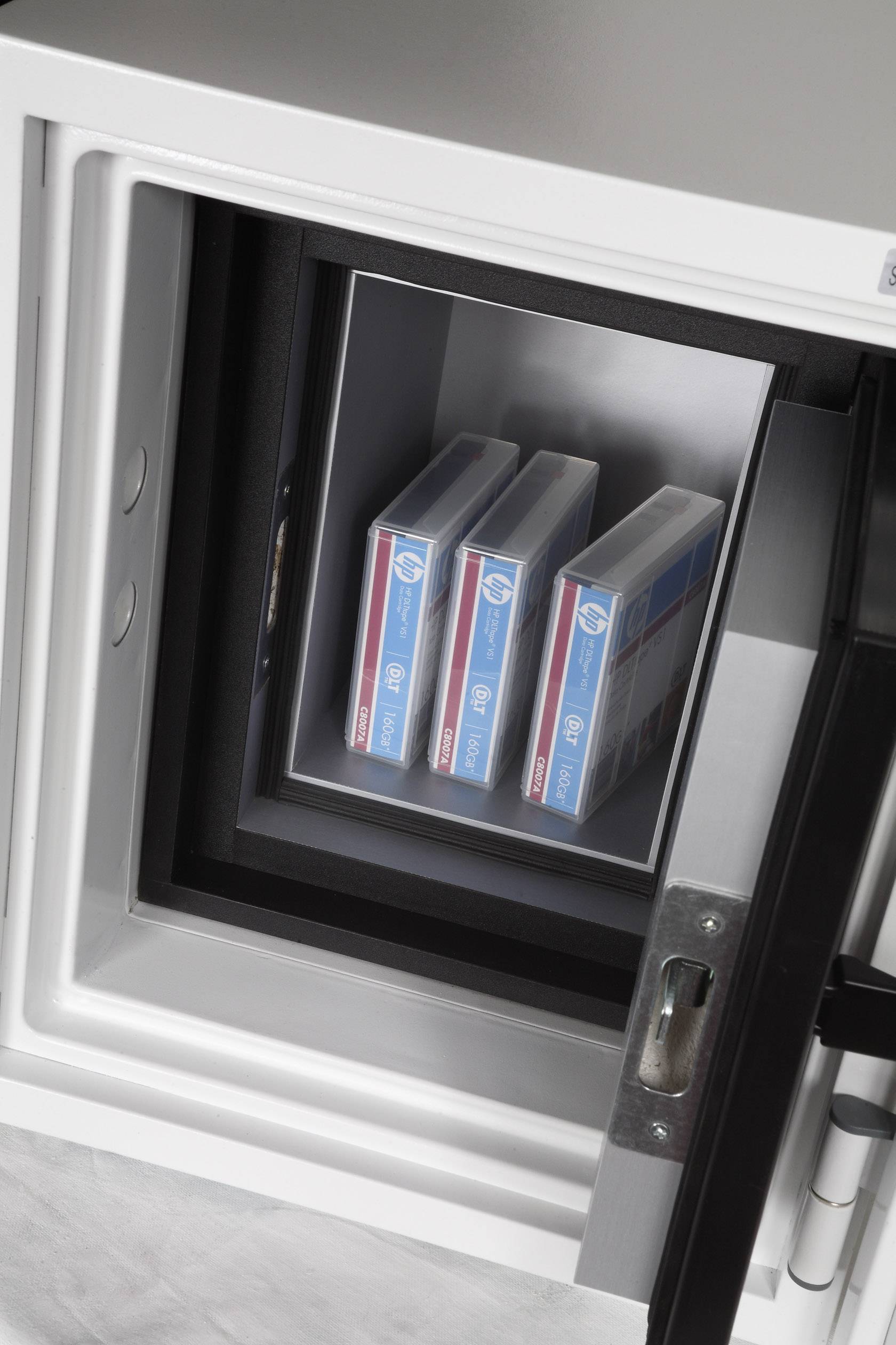 Ein geöffneter Tresor zeigt drei Boxen mit Datenträgern, die sicher gelagert sind. Der Tresor vermittelt Schutz und Sicherheit.