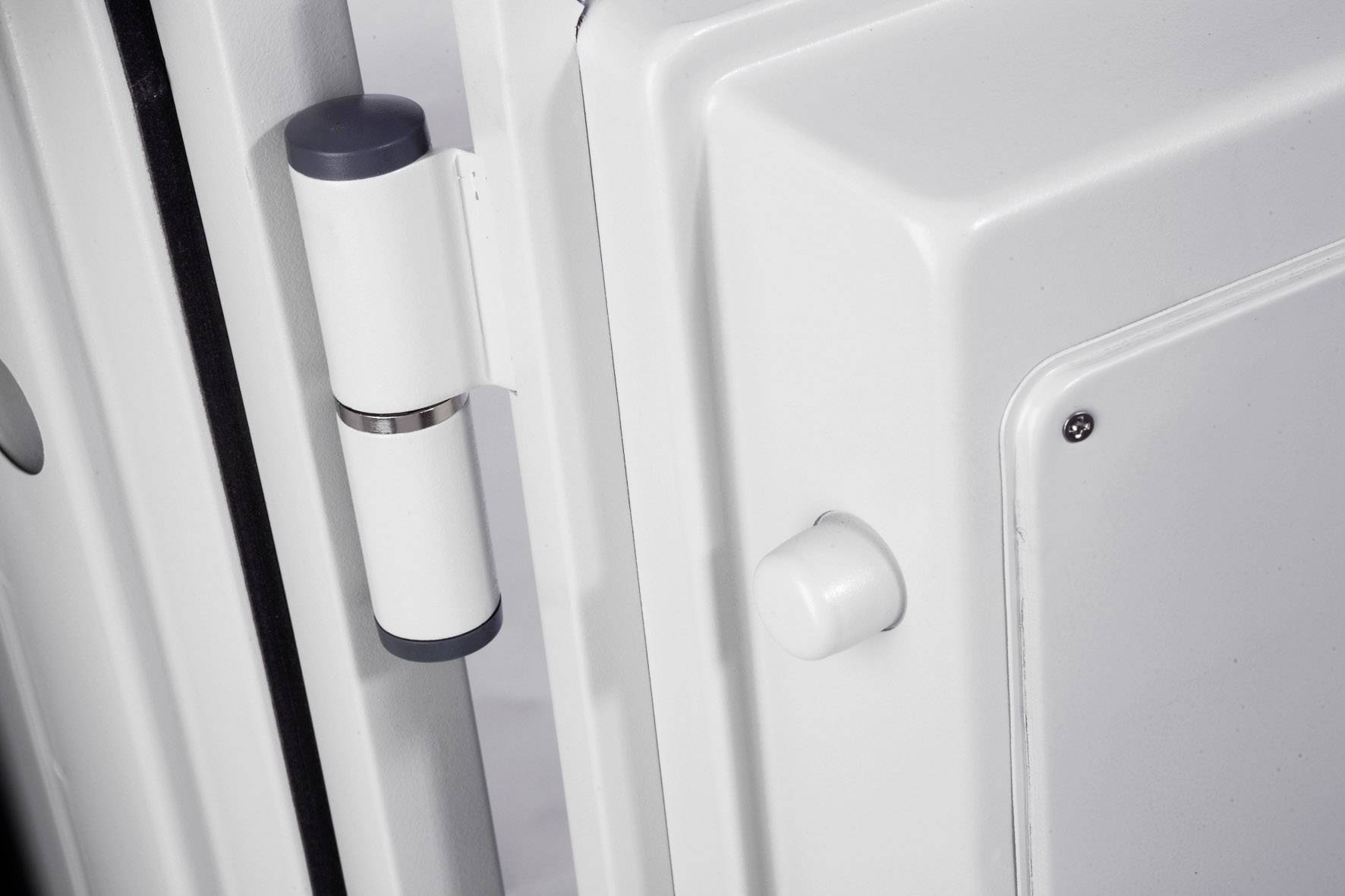 Nahaufnahme eines weißen Möbelscharnier- oder Türscharniers, das an einer weißen Tür oder einem Schrank montiert ist.