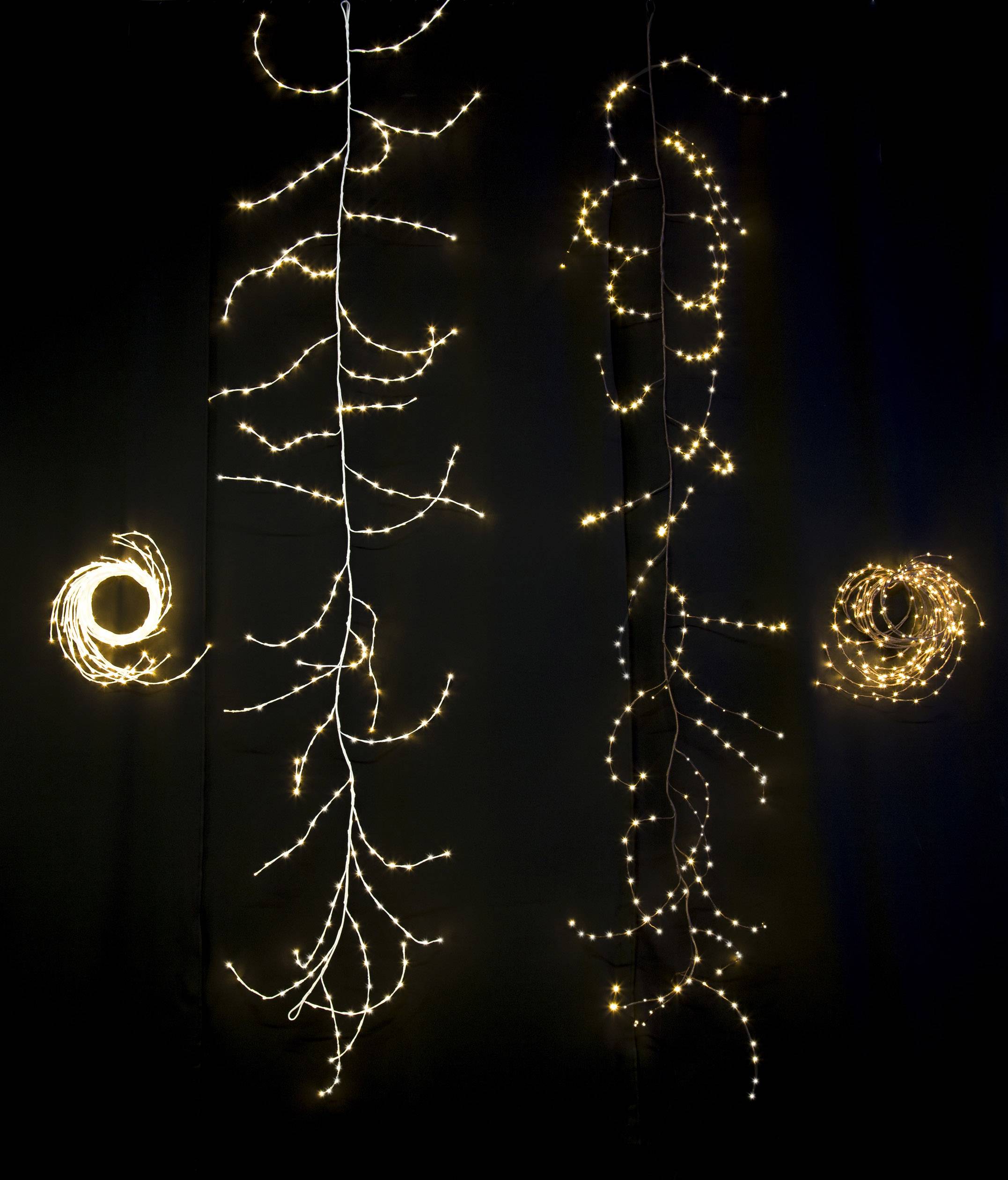 Lichterketten hängen vor einem dunklen Hintergrund, in verschiedenen Formen angeordnet. Zwei sind spiralförmig, zwei baumartig.