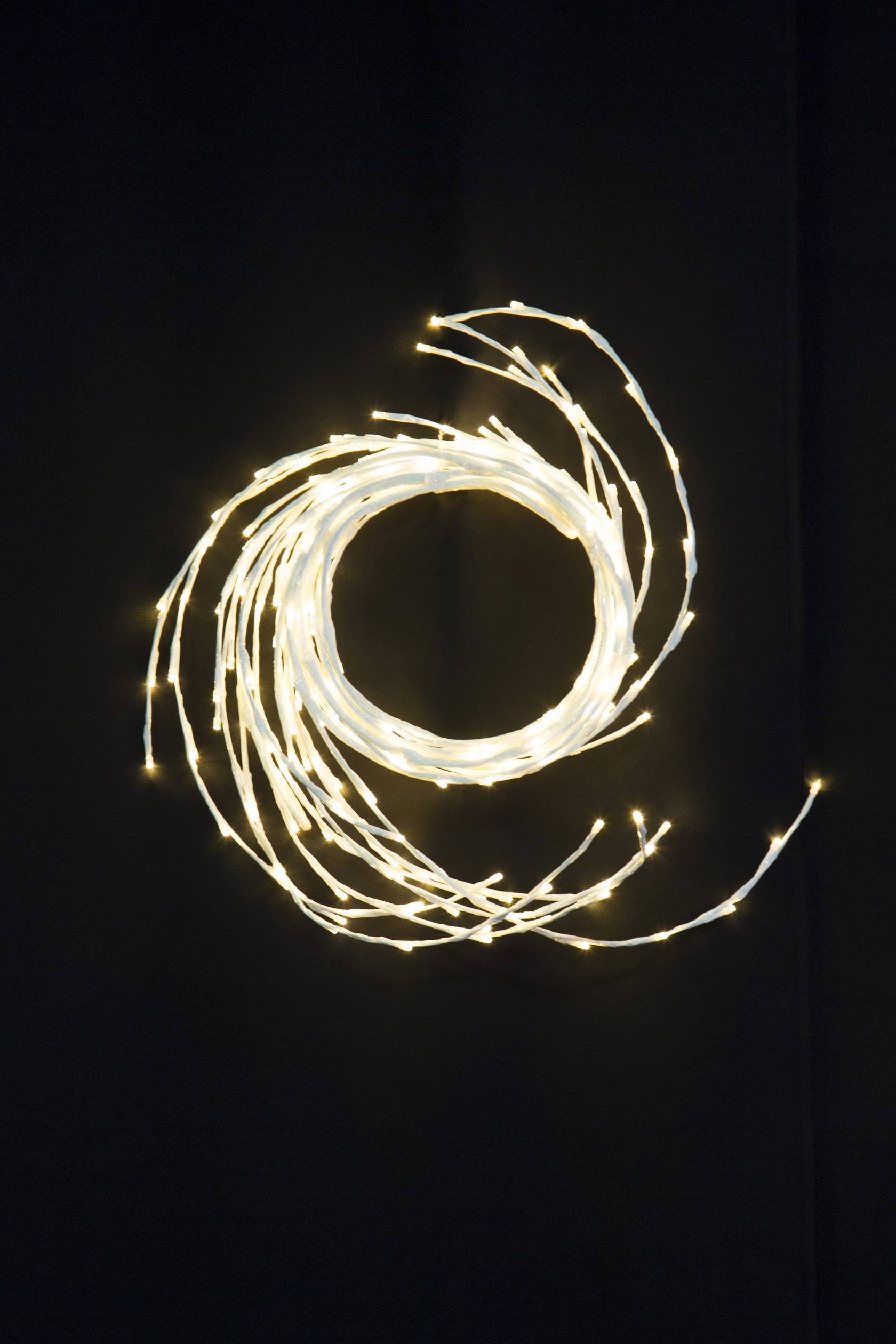 Ein Kreis aus Lichterketten formt ein spiralförmiges Muster auf schwarzem Hintergrund.