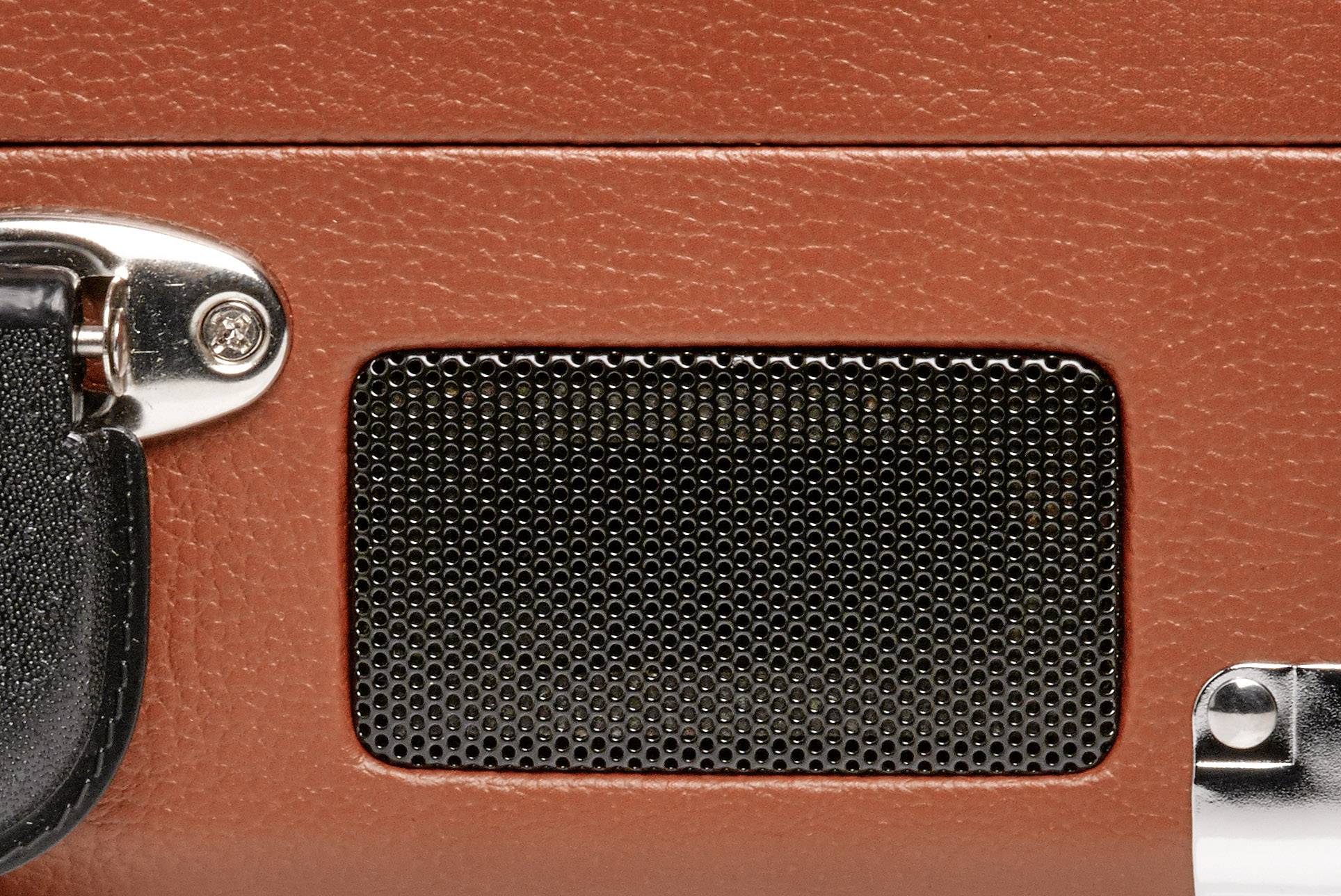 Nahaufnahme eines Lautsprechers in einem vintage-braunen Gehäuse mit silbernen Akzenten. Der Fokus liegt auf dem Gitter des Lautsprechers.