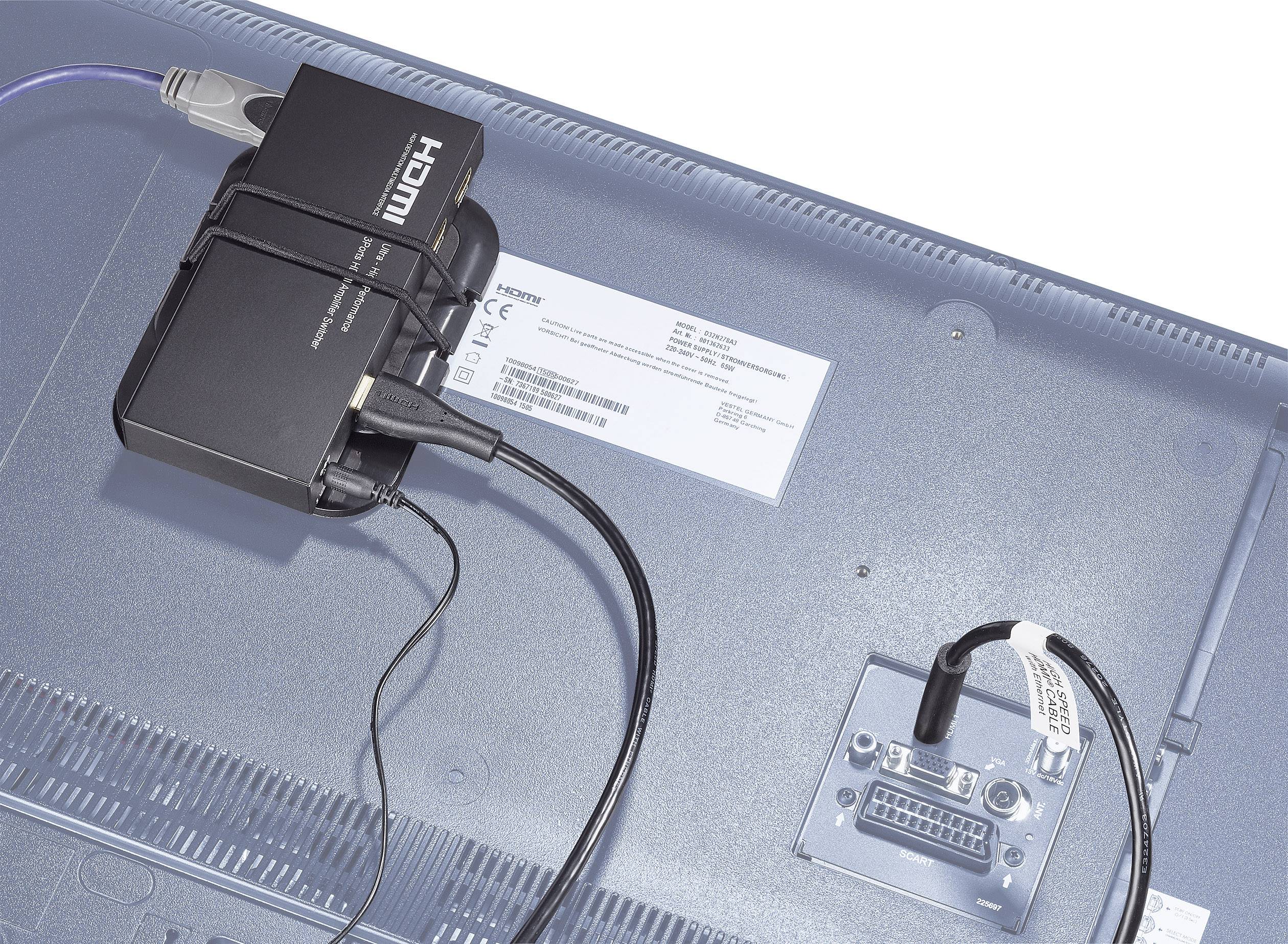 Ein schwarzer HDMI-Konverter ist mit dem HDMI-Anschluss an der Rückseite eines Monitors verbunden. Kabel führen vom Konverter weg.