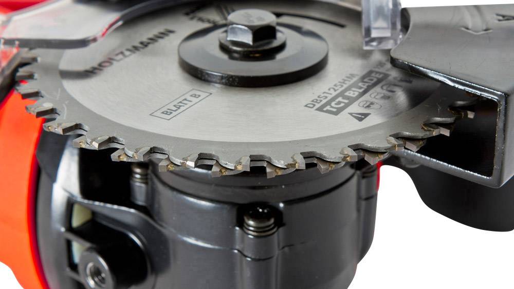 Nahaufnahme einer Kreissäge mit sichtbar scharfen Zähnen und stabiler Halterung. Die Marke 'Holzmann' ist auf der Klinge erkennbar.