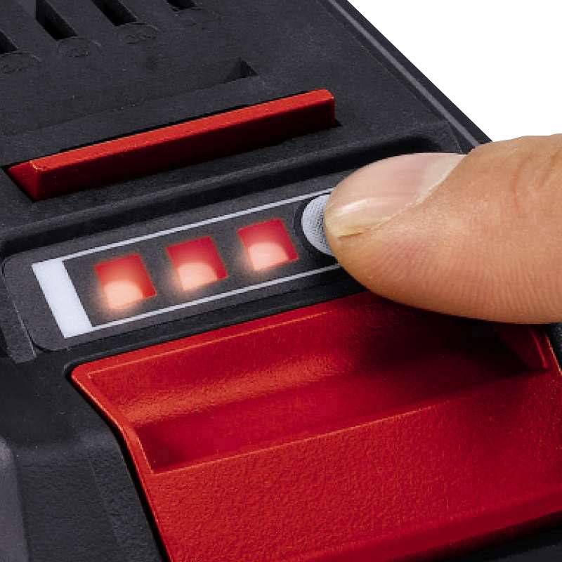 Ein Finger drückt auf einen beleuchteten Knopf eines elektronischen Geräts, umgeben von roten Lichtern und einer Anzeige.