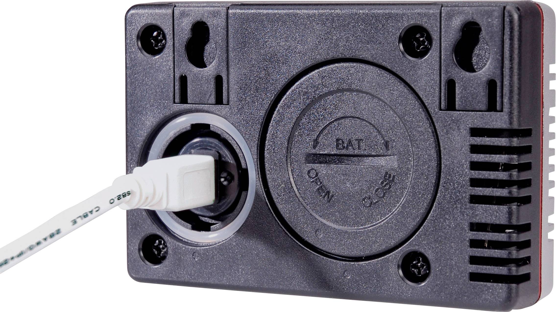 Ein schwarzes elektrisches Gerät mit einem angeschlossenen weißen Kabel. Es gibt eine kreisförmige Batterieabdeckung mit den Markierungen 'Open' und 'Close'.