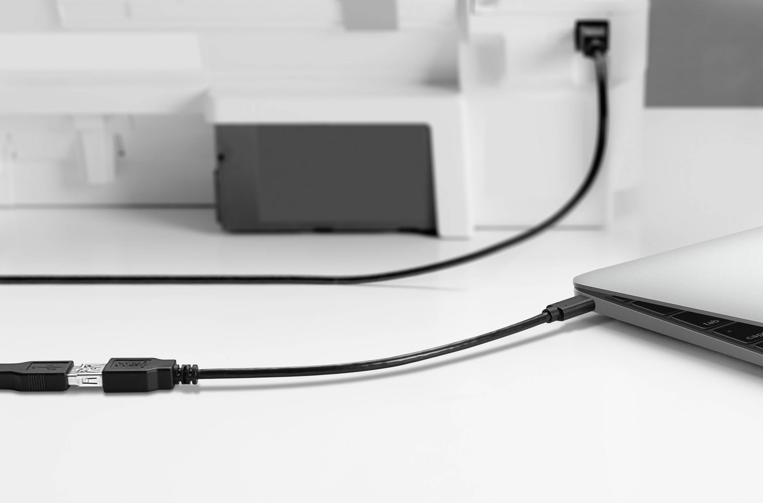 Ein Laptop ist über ein USB-Kabel mit einem Drucker verbunden.