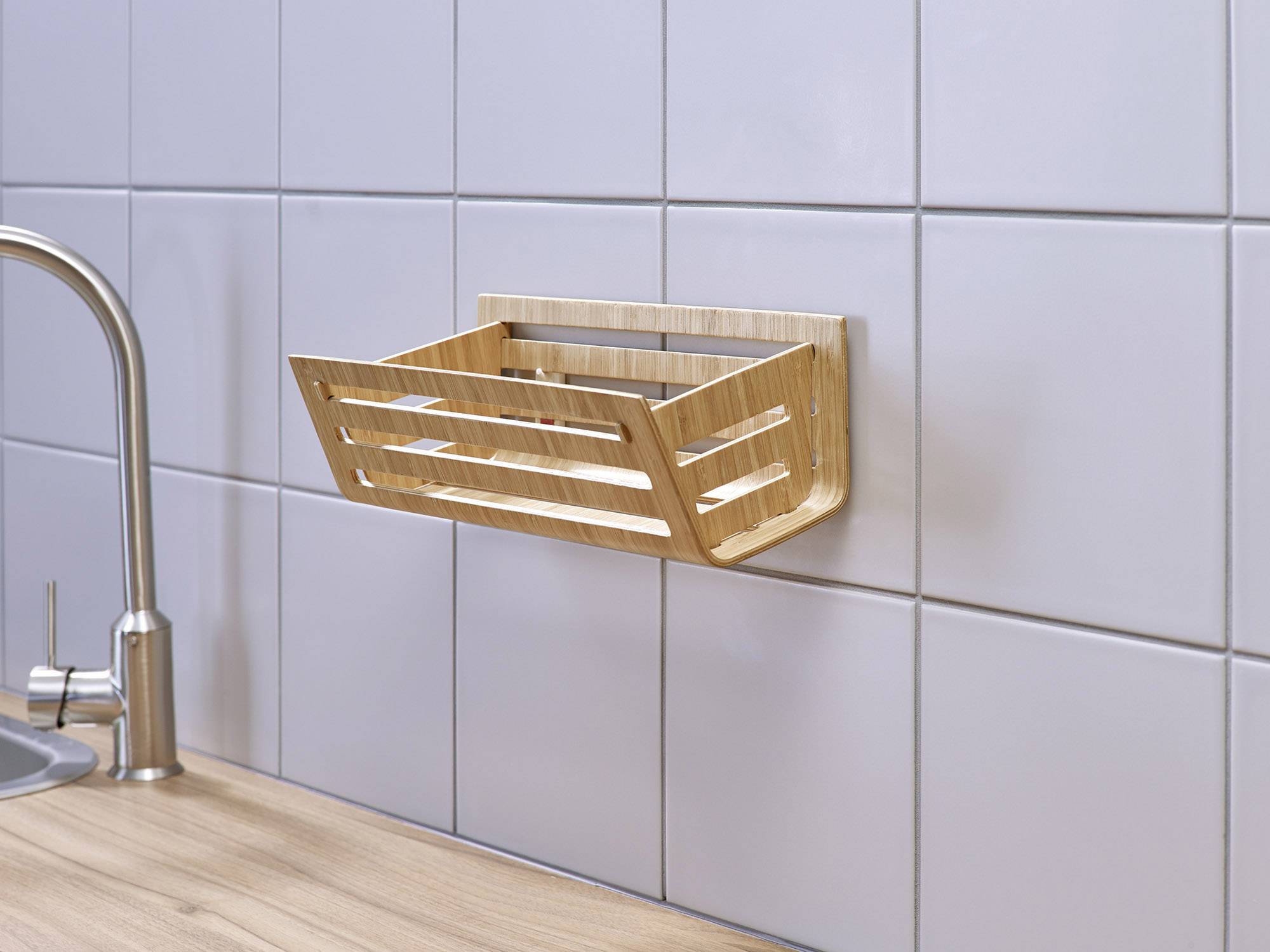 Ein hölzerner Gewürzhalter ist an einer gefliesten Küchenwand montiert, in der Nähe eines Wasserhahns auf einer Arbeitsplatte.