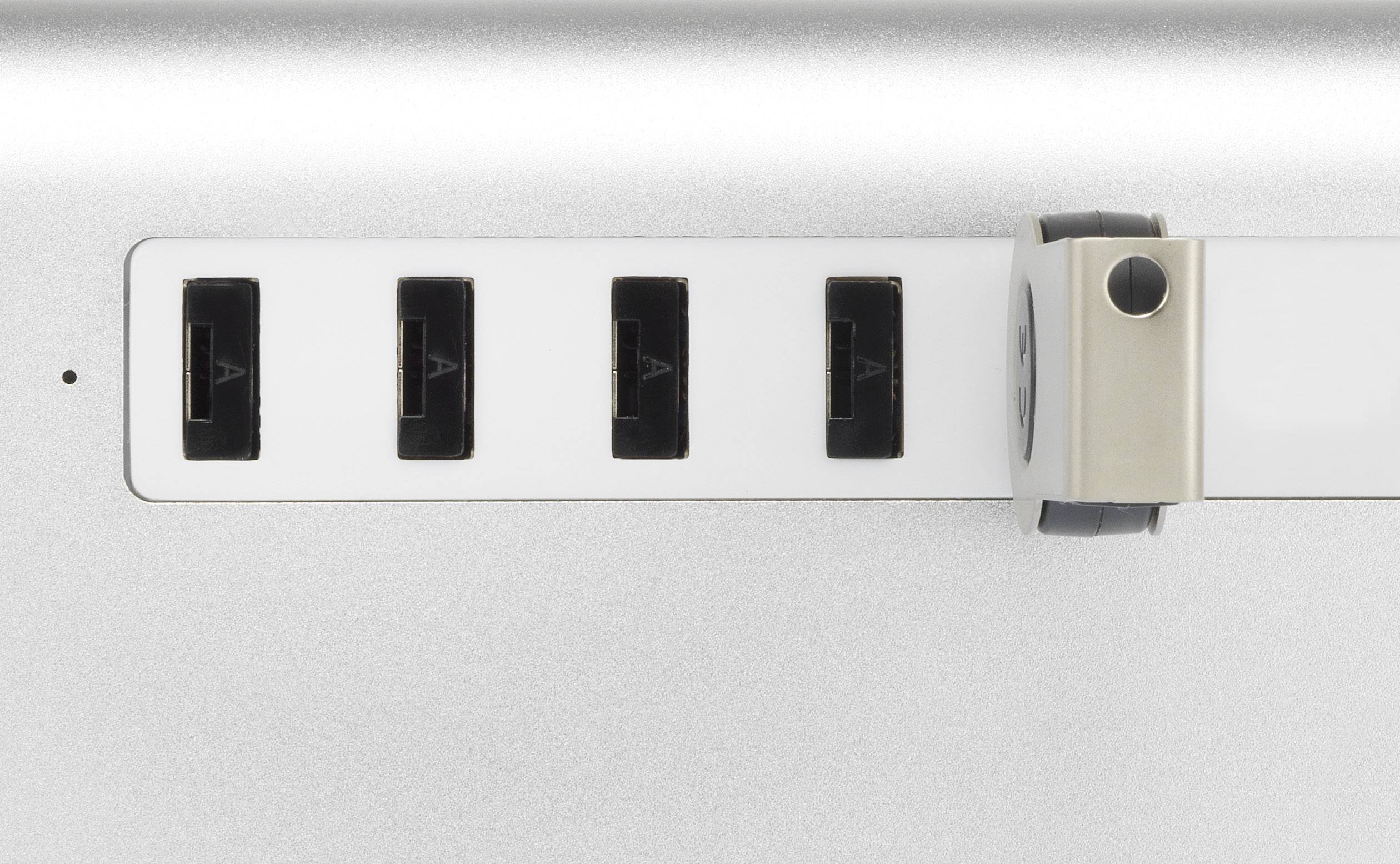 Vier USB-Anschlüsse auf einer silbernen Metalloberfläche, flankiert von einem runden, drehbaren Verschluss.