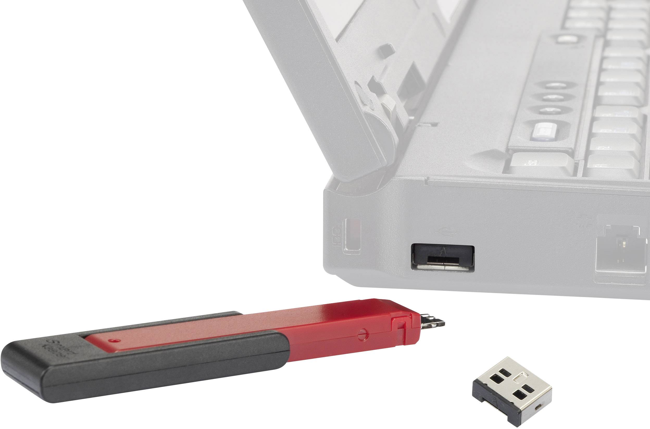 Ein USB-Dongle und Adapter liegen nahe einem Laptop. Der Laptop ist leicht geöffnet und zeigt USB-Anschlüsse an der Seite.