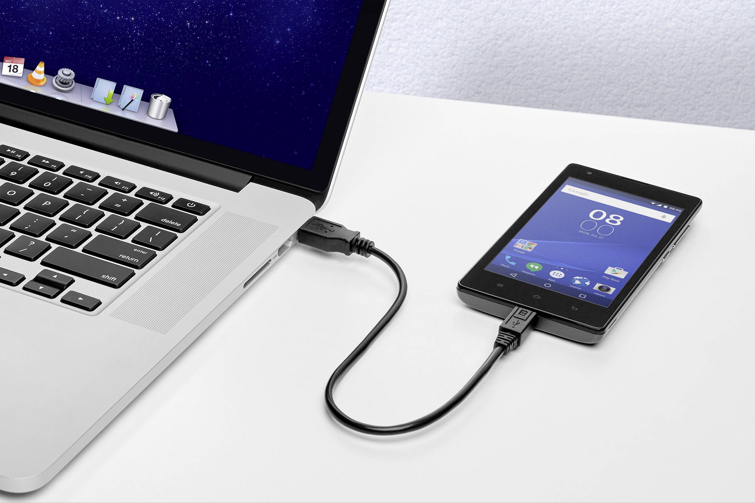 Ein Laptop ist über ein USB-Kabel mit einem Smartphone verbunden. Beide Geräte sind eingeschaltet; ein Datenaustausch scheint stattzufinden.
